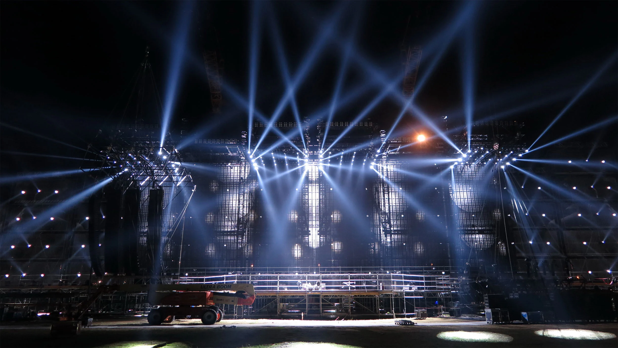 Palco vuoto del Modena Park di notte durante le prove, fasci di luce bianca a ventaglio dalle torri di americane – Vasco Rossi Modena Park, Italia, 2017 – scenografia per concerti