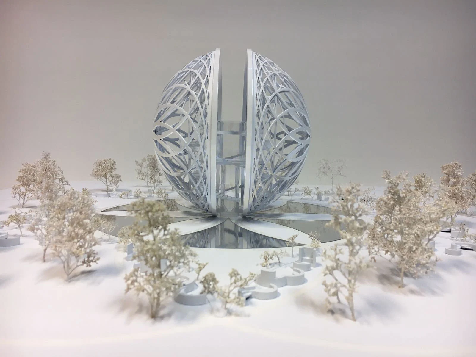 Modello della Leosphere: una sfera bianca divisa di costoloni intrecciati su una vasca riflettente tra alberi in miniatura – Leosphere, Chicago, Stati Uniti, 2022 – architettura, concept