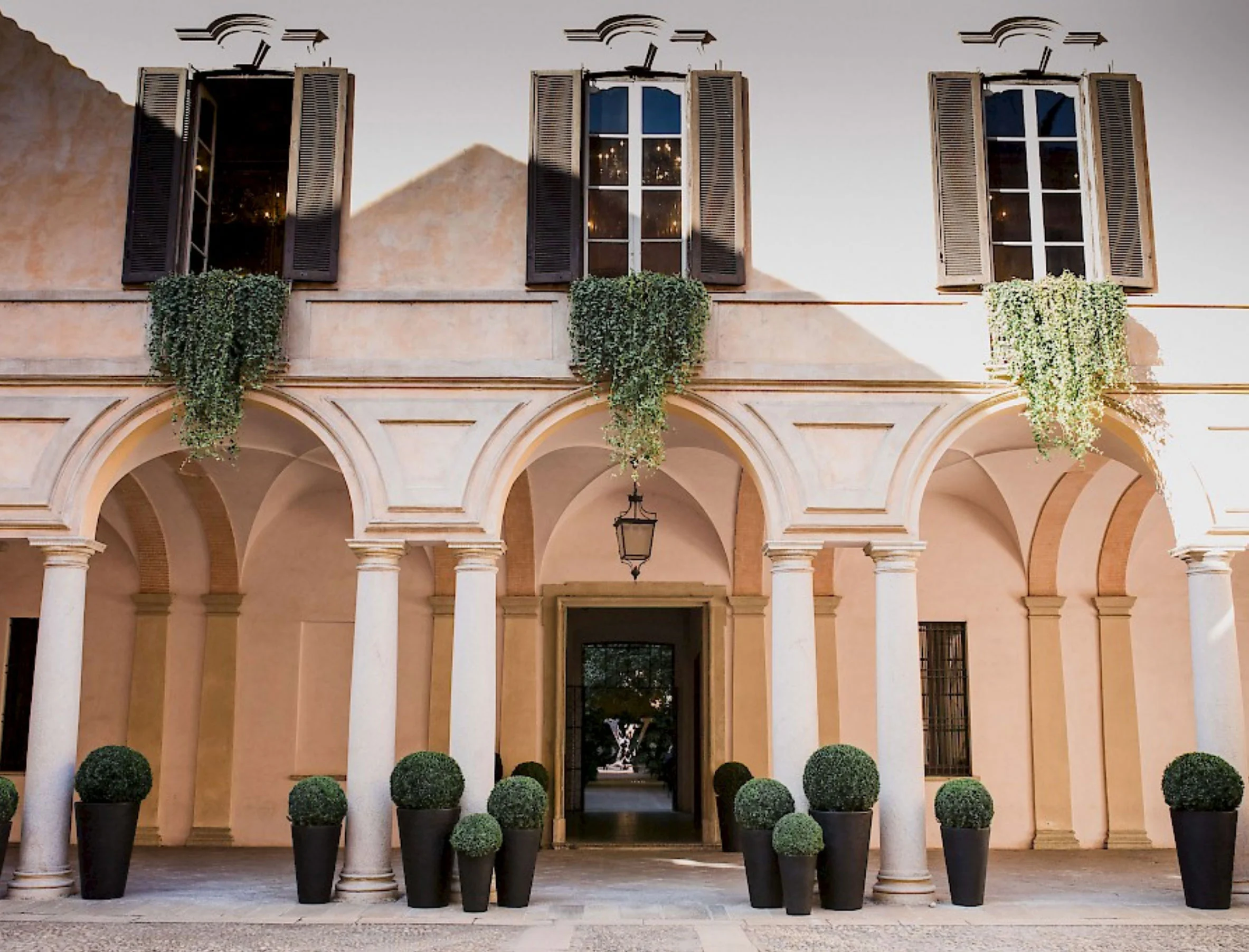 Facciata del cortile di Palazzo Clerici con verde pendente sotto le finestre e sfere di bosso in vaso – Louis Vuitton a Palazzo Clerici, Milano, Italia, 2019 – allestimento espositivo