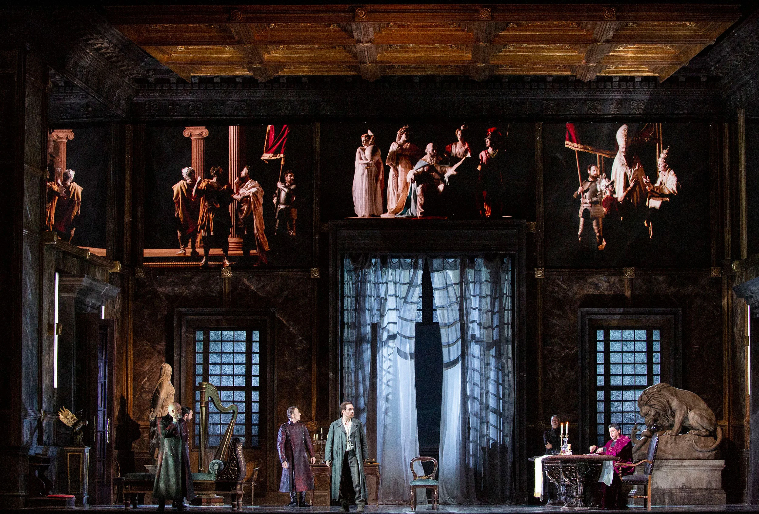 Scenografia di un interno di palazzo con soffitto a cassettoni e quadri viventi di figure in costume sopra i cantanti – Tosca al Teatro alla Scala, Milano, Italia, 2019 – scenografia d'opera