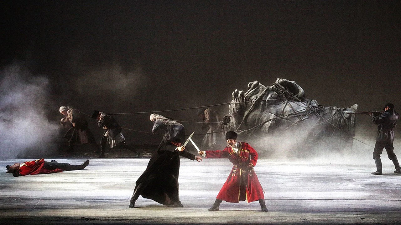 Due spadaccini in duello su un palco fumoso, uno in uniforme rossa, con la scultura di un cavallo caduto dietro – Tamerlano al Teatro alla Scala, Milano, Italia, 2017 – scenografia d'opera