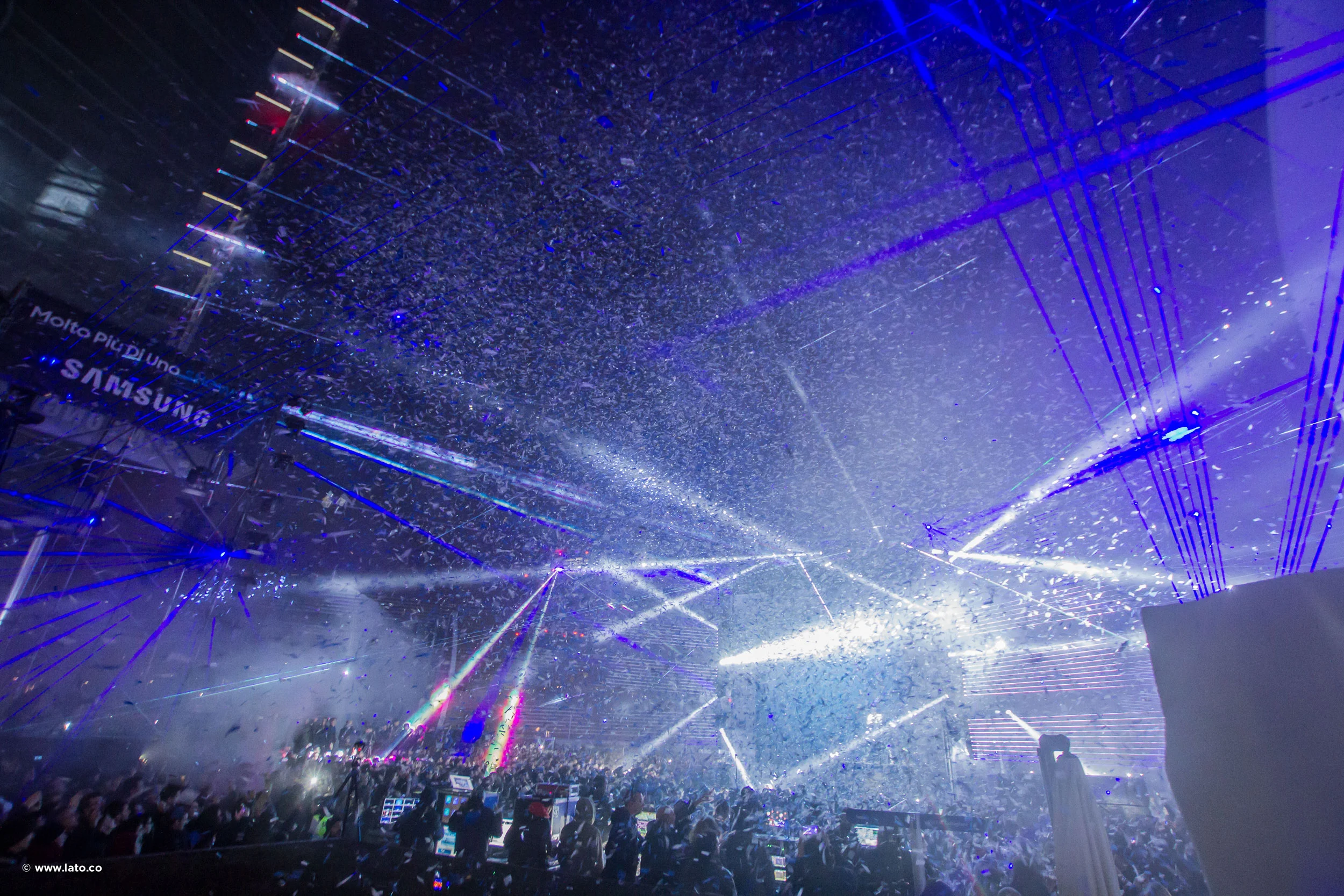Pioggia di coriandoli e raggi laser sul pubblico allo show Samsung, con uno schermo brandizzato a sinistra – Samsung Galaxy S7 Laser Show, Milano, Italia, 2016 – progettazione di eventi