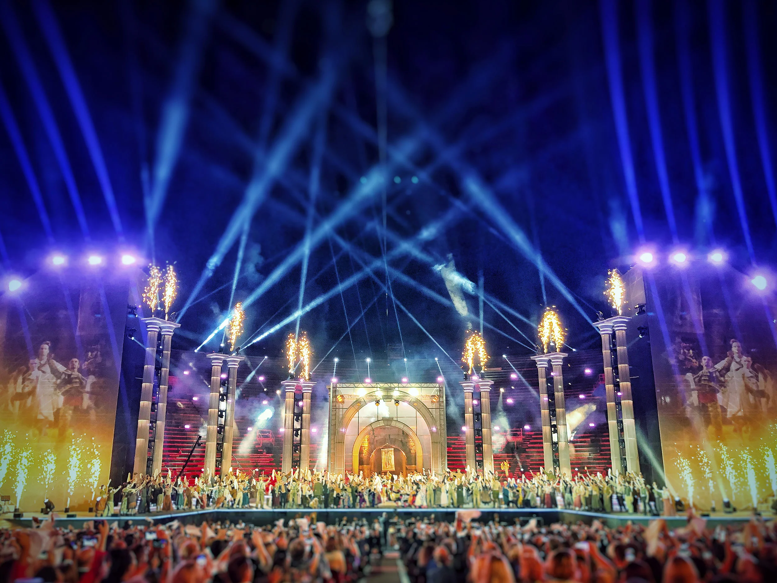 Gran finale all'Arena di Verona: effetti di fuoco in cima alle colonne, fontane di scintille e tutto il cast schierato sul palco – La Notte di Andrea Bocelli all'Arena di Verona, Italia, 2018 – scenografia per concerti