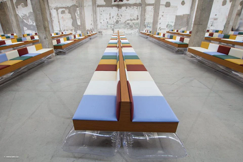Lunghe file di panche multicolori che convergono verso il fondo del capannone industriale – Marni Ready-to-Wear Primavera 2017, Milano, Italia – scenografia per sfilate