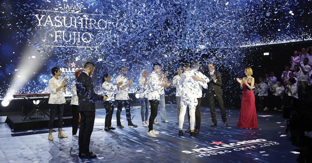 Coriandoli che cadono sugli chef sul palco mentre il nome del vincitore appare sullo schermo alle spalle – S.Pellegrino Young Chef, Milano, Italia, 2019 – progettazione di eventi