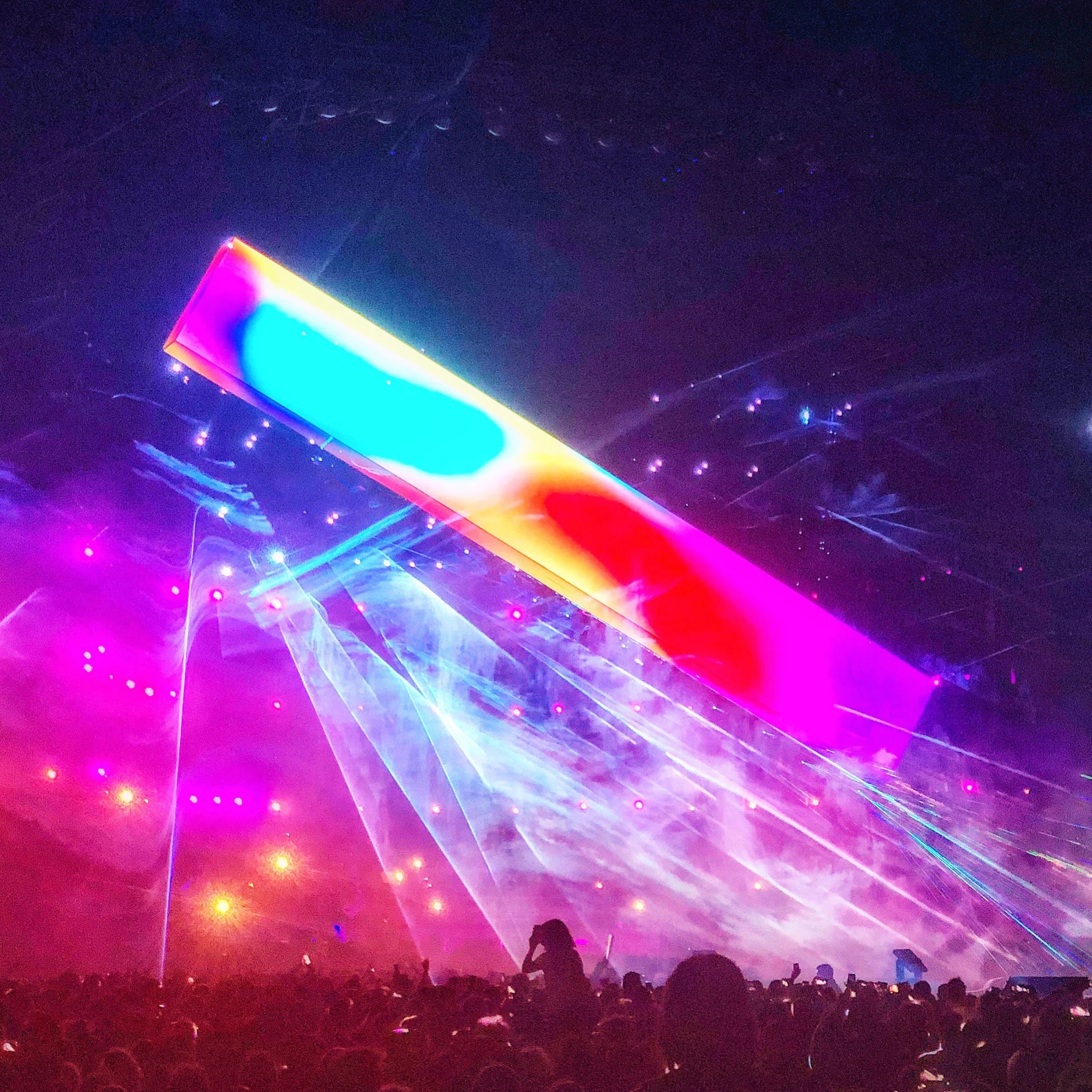 Una singola barra video inclinata in colori vivaci sopra raggi laser e un pubblico in festa – Cesare Cremonini Stadi 2018, Italia – scenografia per concerti