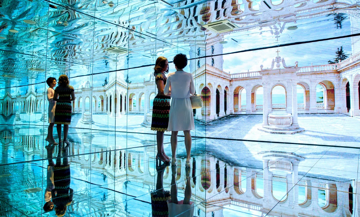Visitatori in una sala a specchi dove gli schermi mostrano un cortile italiano porticato, riflesso all'infinito – Padiglione Italia all'Expo 2015, Milano, Italia – allestimento espositivo