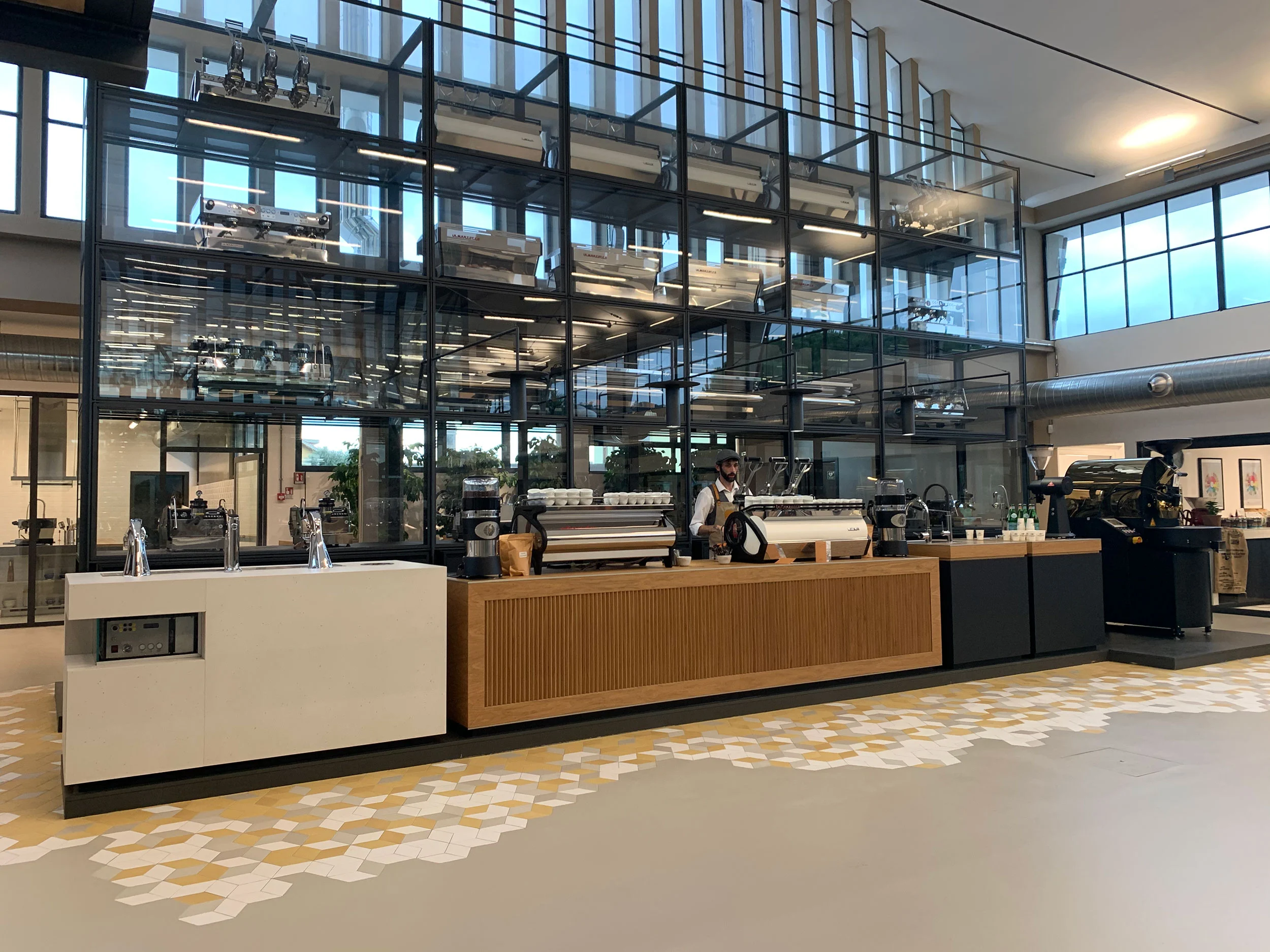 Vista d'insieme della caffetteria e della vetrina su più livelli nella sala della fabbrica riconvertita – La Marzocco Accademia del Caffè Espresso, Firenze, Italia, 2018 – interior design
