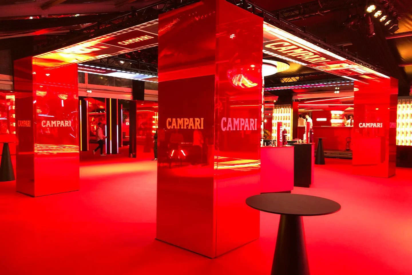 Lounge con moquette rossa, colonne rosse a specchio con il logo Campari e tavolini alti da cocktail – Campari al 75° Festival di Cannes, Francia, 2022 – progettazione di eventi