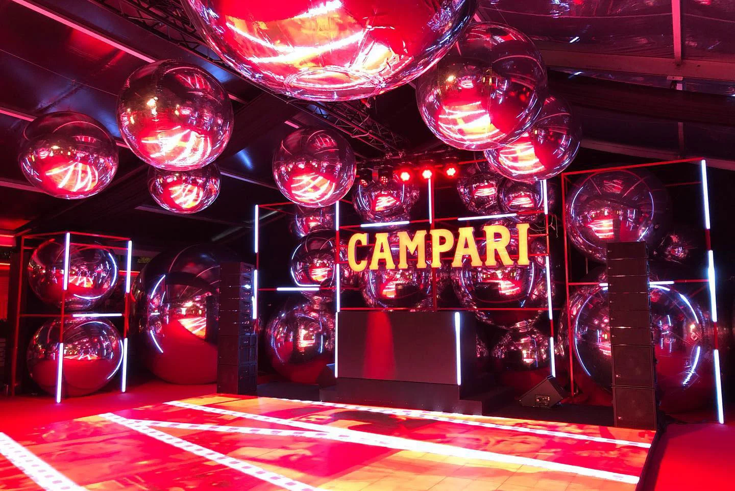 Vista laterale della pista da ballo e della consolle del DJ sotto grappoli di sfere a specchio e cornici al neon – Campari al 75° Festival di Cannes, Francia, 2022 – progettazione di eventi