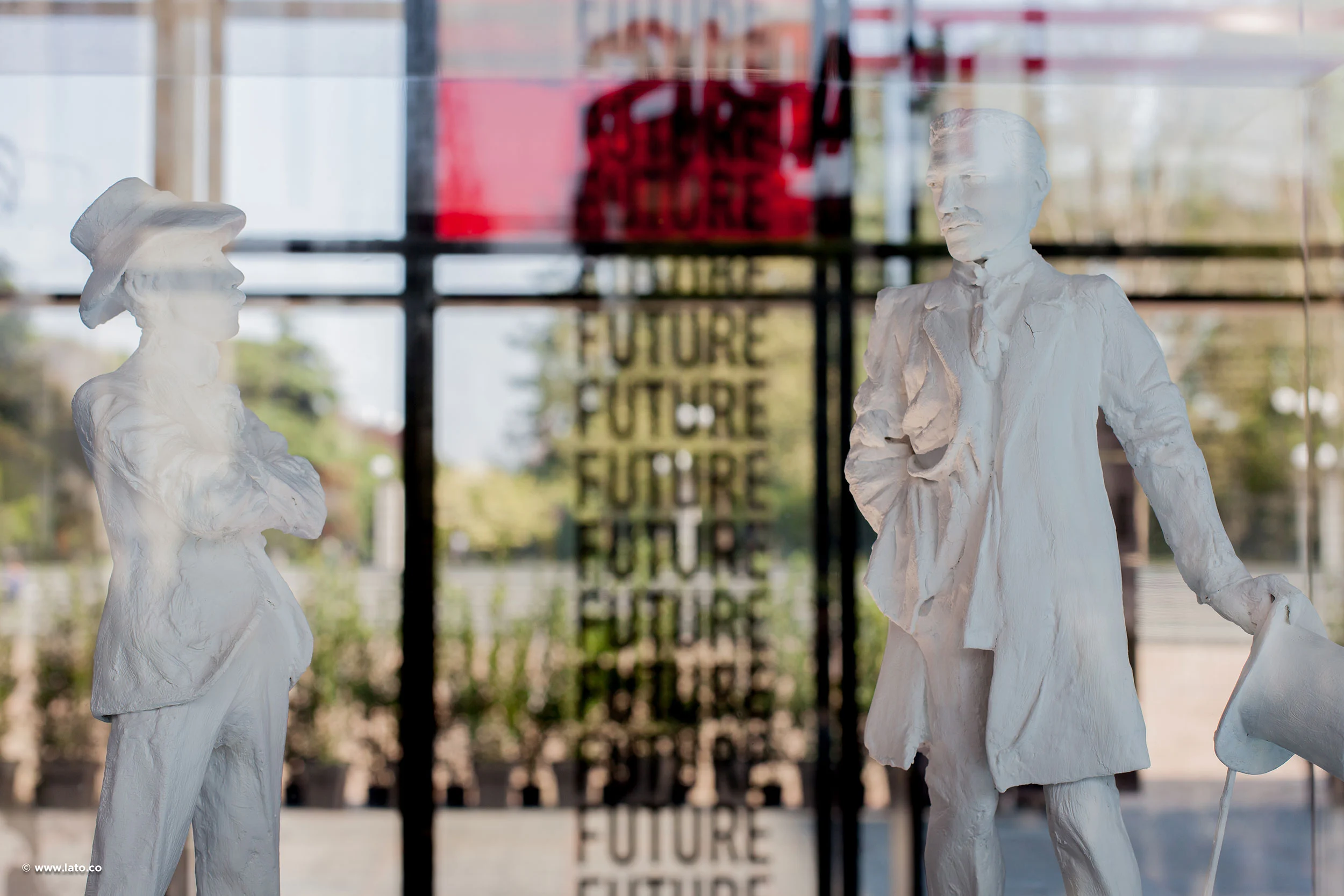 Statuette bianche di due figure davanti a una parete di vetro con stampata la parola Future – Cartier The Legendary Thrill, Milano, Italia, 2018 – progettazione di eventi
