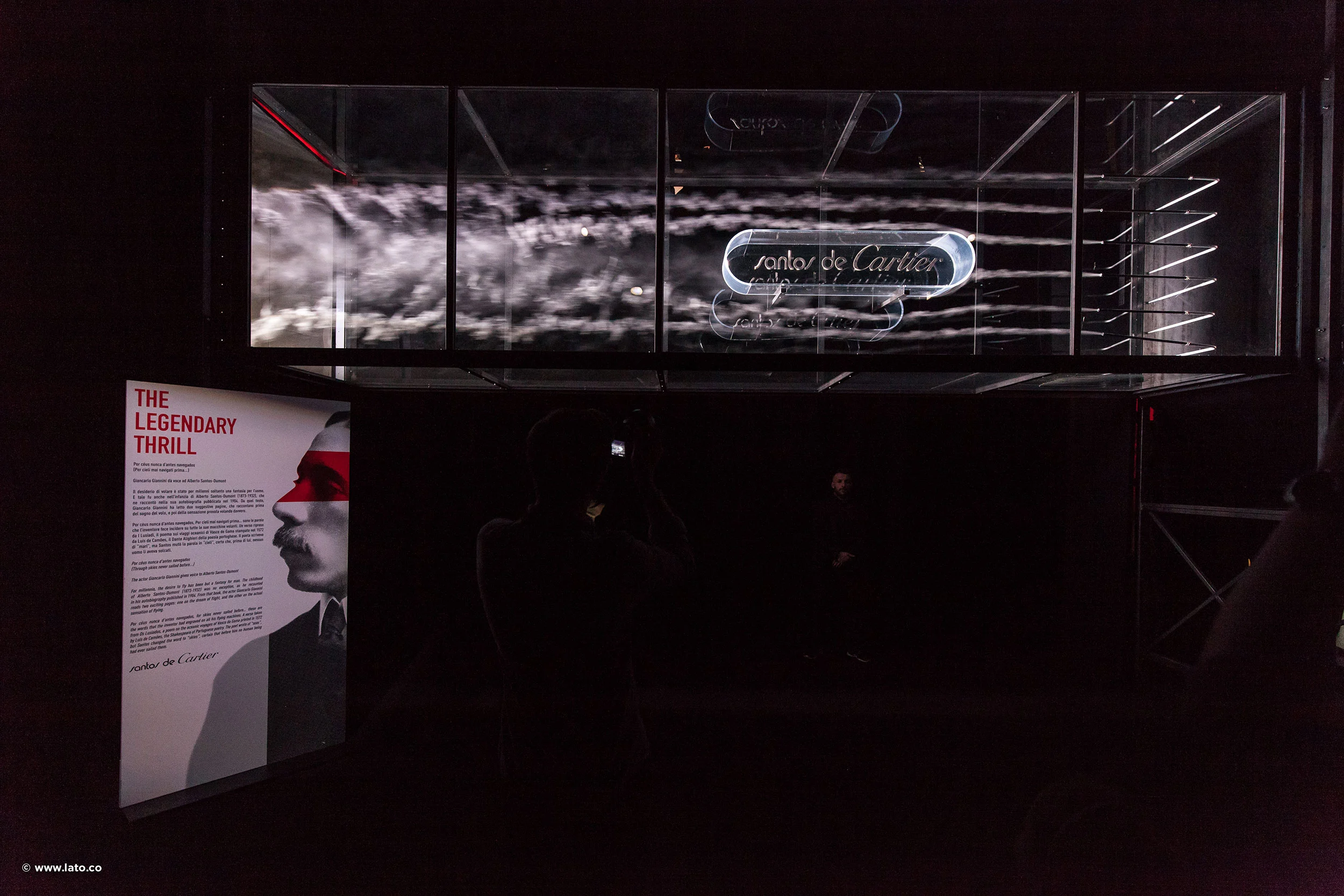 Sala buia con un'insegna Santos de Cartier in una teca di vetro e un pannello luminoso intitolato The Legendary Thrill – Cartier The Legendary Thrill, Milano, Italia, 2018 – progettazione di eventi