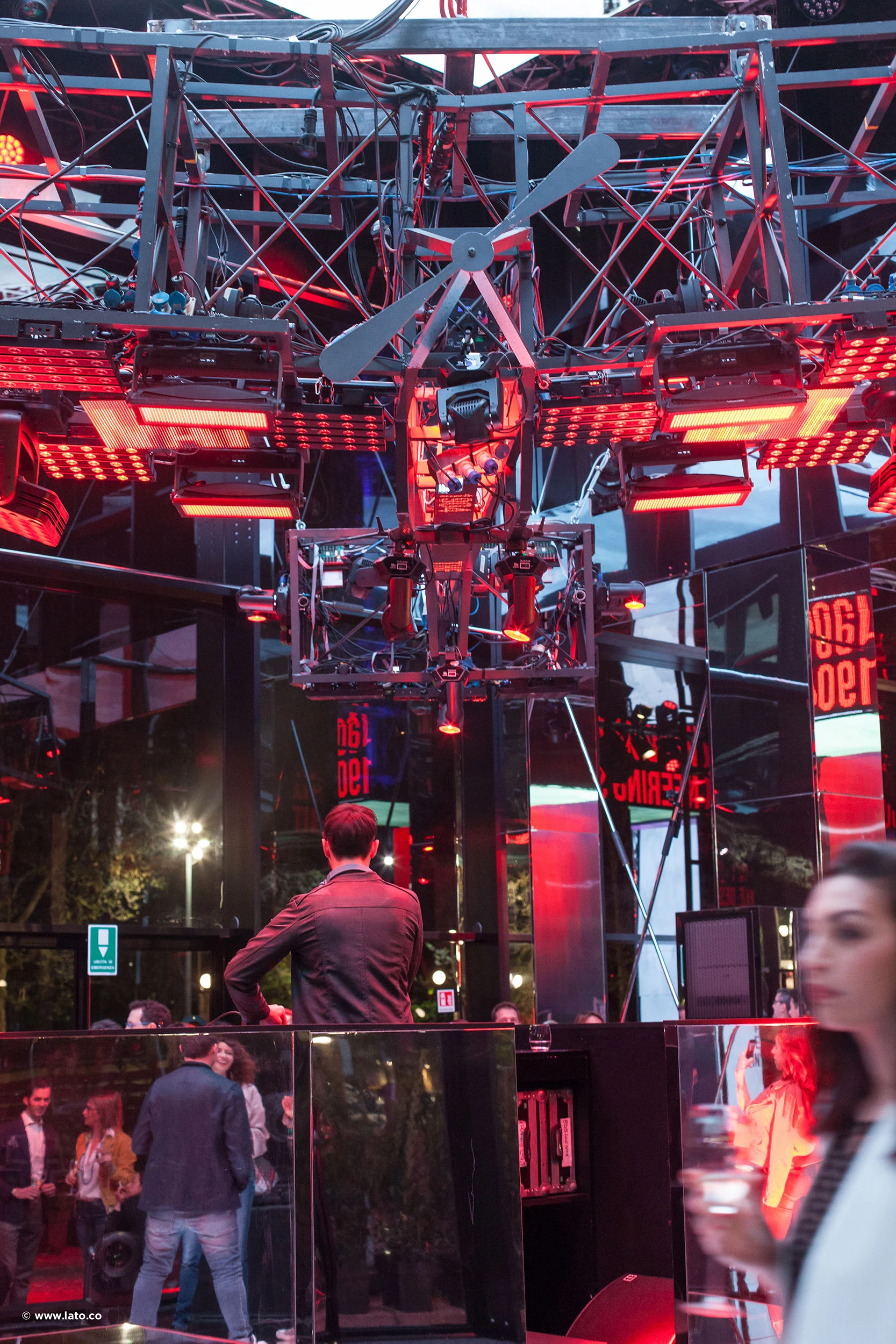 Interno del padiglione: un'elica sospesa e luci rosse appese a un'americana d'acciaio sopra i visitatori – Cartier The Legendary Thrill, Milano, Italia, 2018 – progettazione di eventi