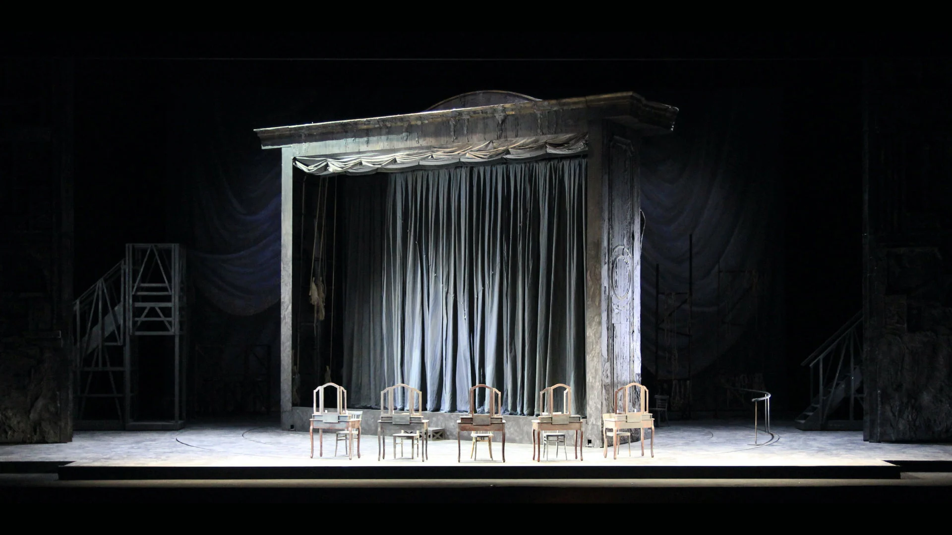 Scenografia di teatro nel teatro: portale consunto con sipario grigio e una fila di tavoli da trucco – Adriana Lecouvreur all'Opéra de Monte-Carlo, Principato di Monaco, 2026 – scenografia d'opera