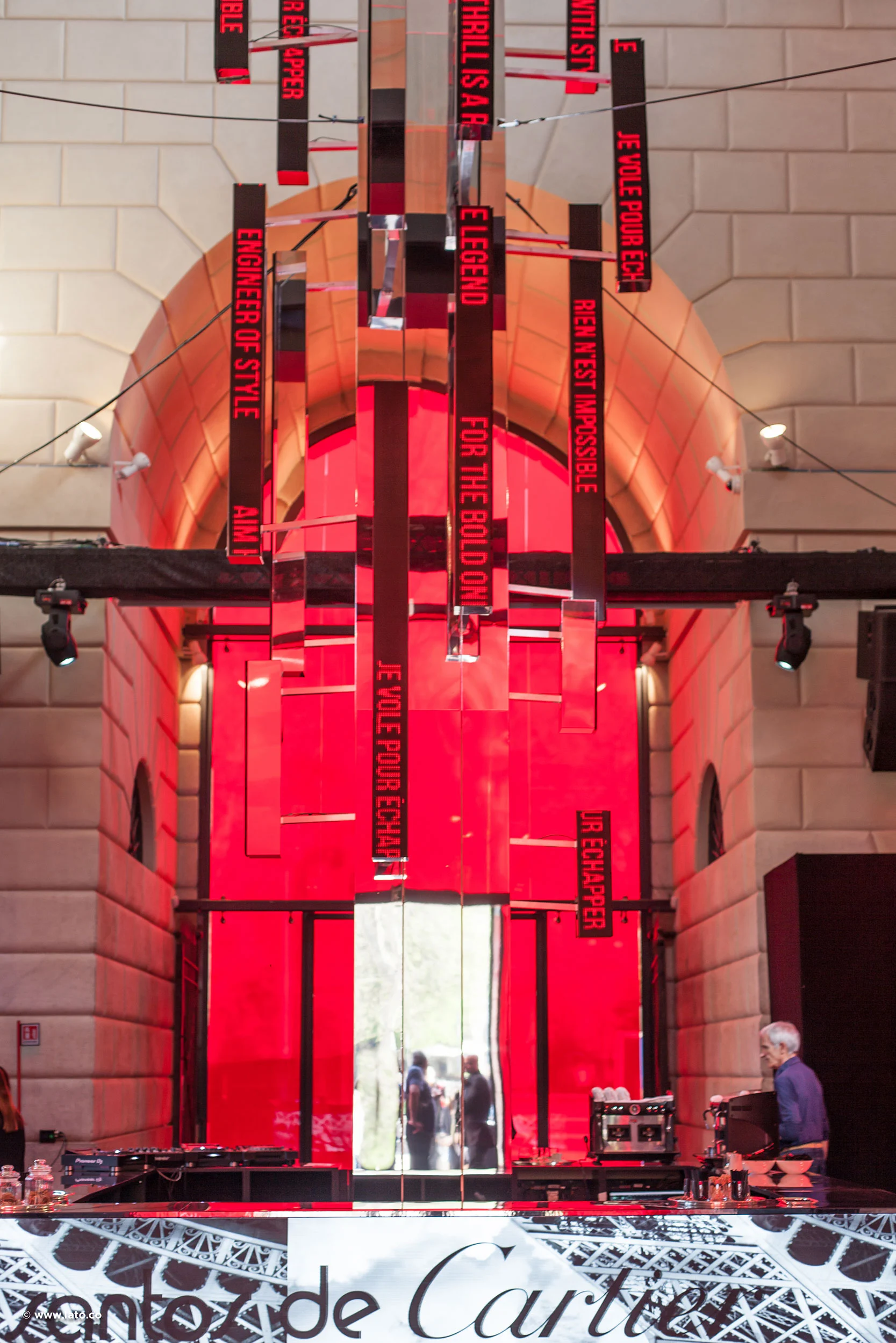 Pannelli rossi con messaggi appesi e strisce a specchio sotto una volta in pietra, sotto Santos de Cartier – Cartier The Legendary Thrill, Milano, Italia, 2018 – progettazione di eventi