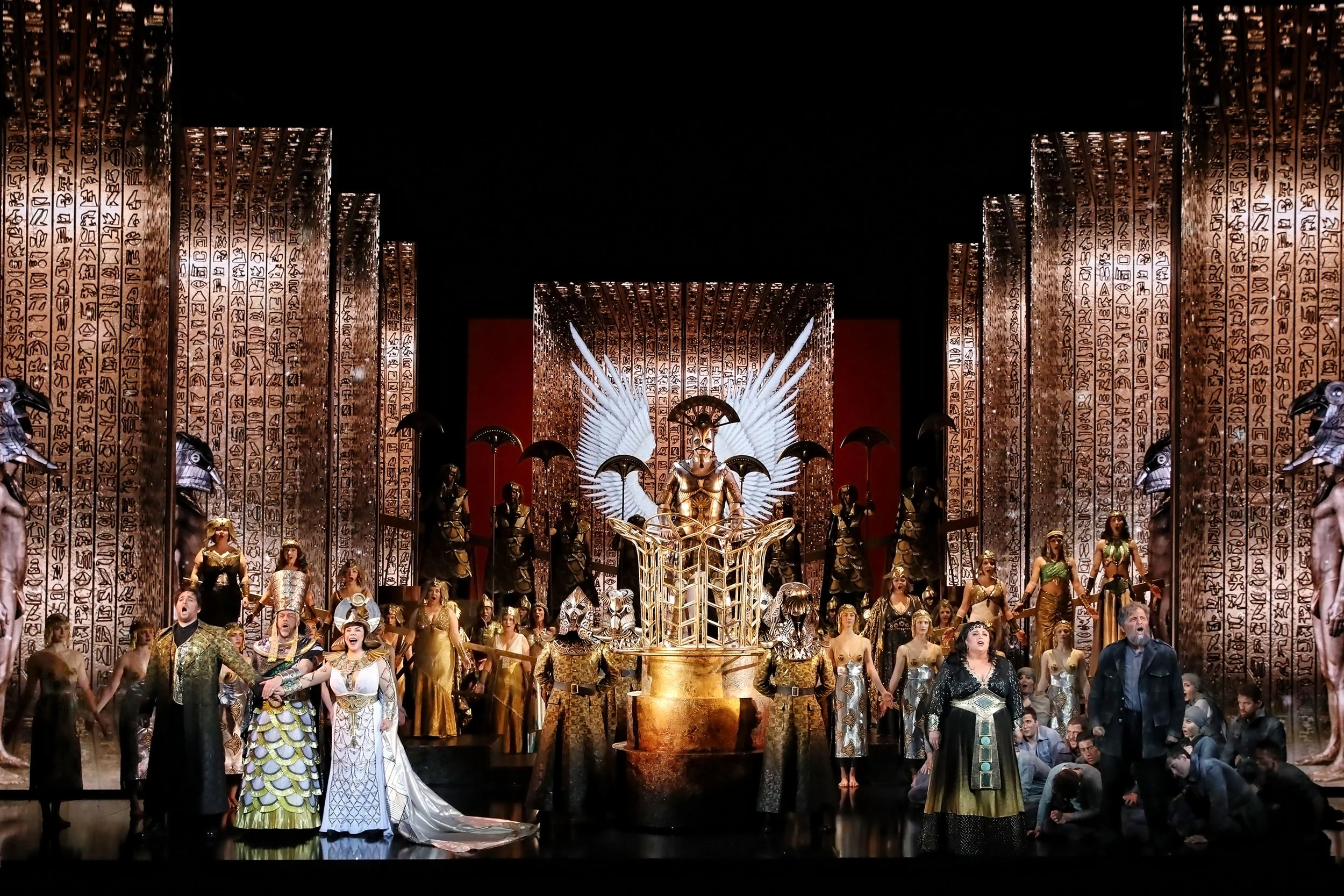 Finale di Aida: tutto il cast davanti a imponenti pareti dorate incise di geroglifici e a un idolo d'oro alato – Aida alla Sydney Opera House, Australia, 2018 – scenografia d'opera