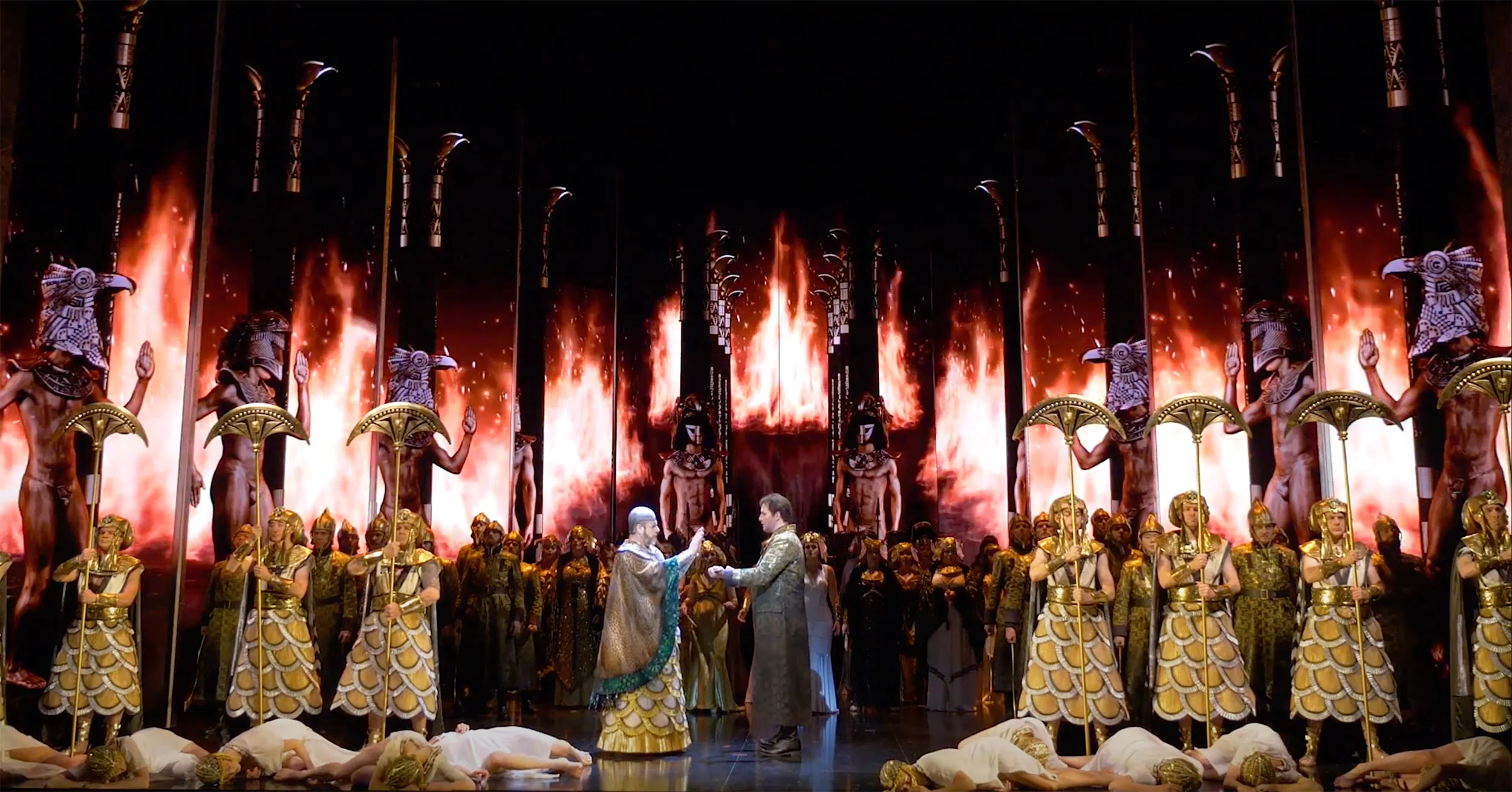 Scena del trionfo con guardie e danzatori davanti a statue dorate e schermi video con fiamme – Aida alla Sydney Opera House, Australia, 2018 – scenografia d'opera