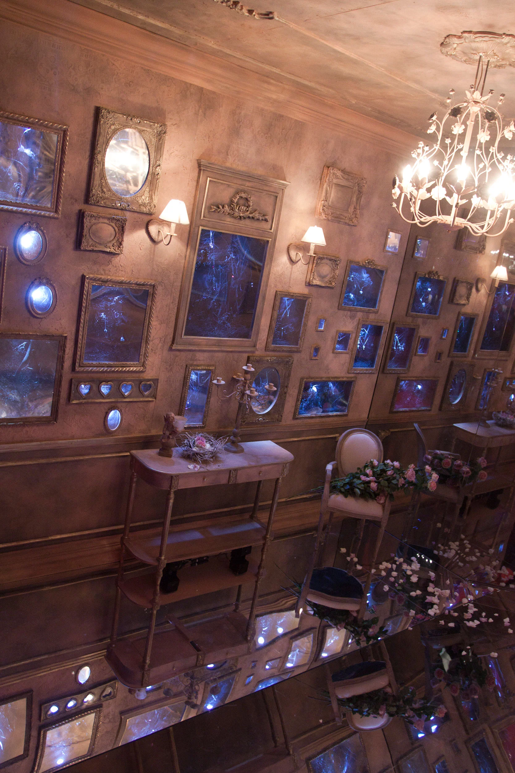 Sala a specchi con antiche cornici dorate, applique, lampadario e sedie ornate di fiori, vista dall'alto – Swarovski Fashionation Party a Palazzo Reale, Milano, Italia, 2011 – progettazione di eventi