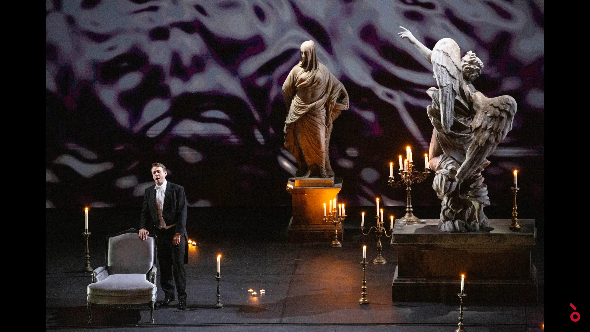 Cantante accanto a una poltrona tra candele e statue di marmo, riflessi d'acqua proiettati alle spalle – A Riveder le Stelle al Teatro alla Scala, Milano, Italia, 2020 – scenografia d'opera
