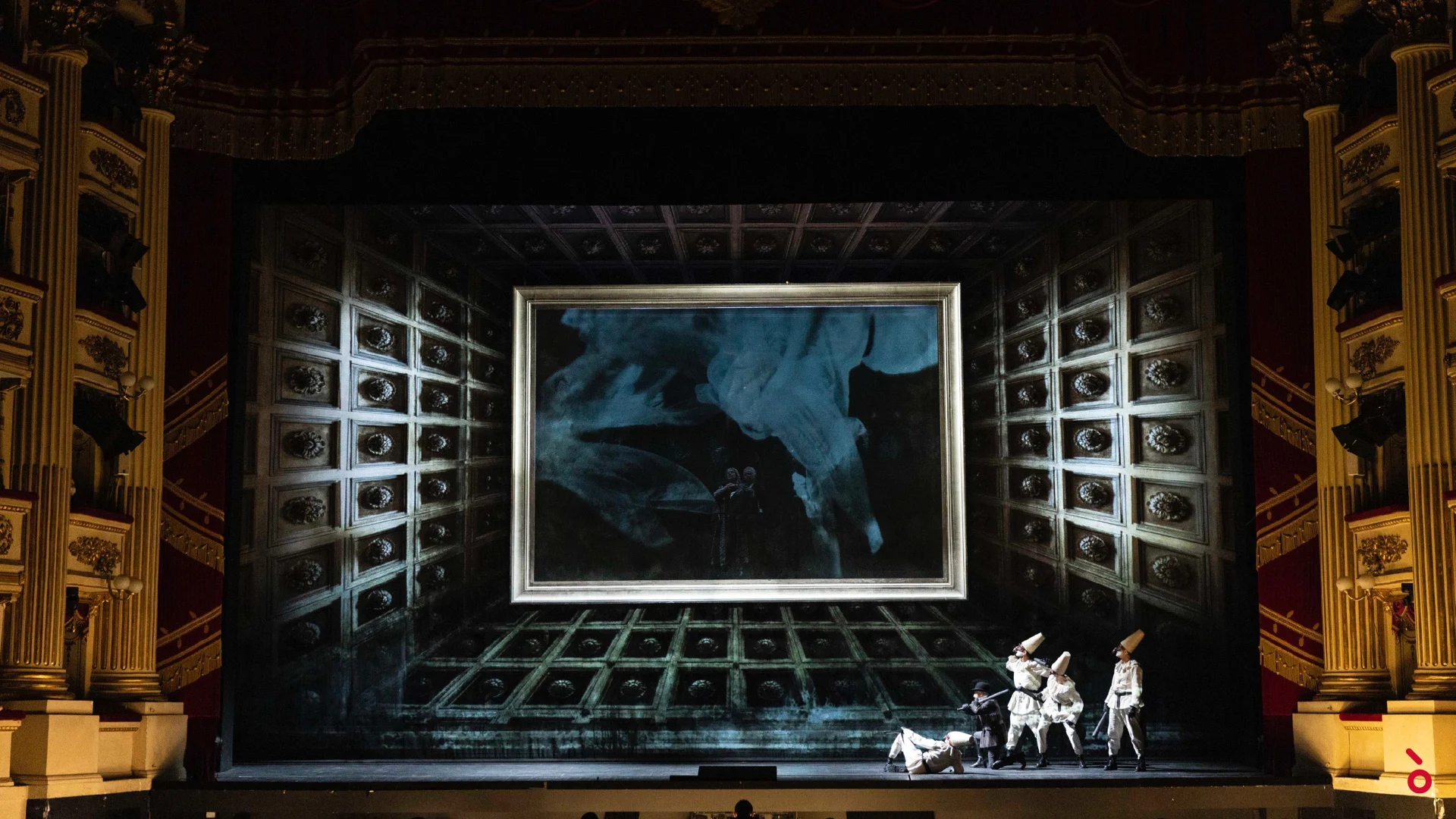 Figure mascherate in bianco davanti a un'enorme cornice dorata in una scenografia a scatola con soffitto a cassettoni e decori – La Gioconda al Teatro alla Scala, Milano, Italia, 2022 – scenografia d'opera