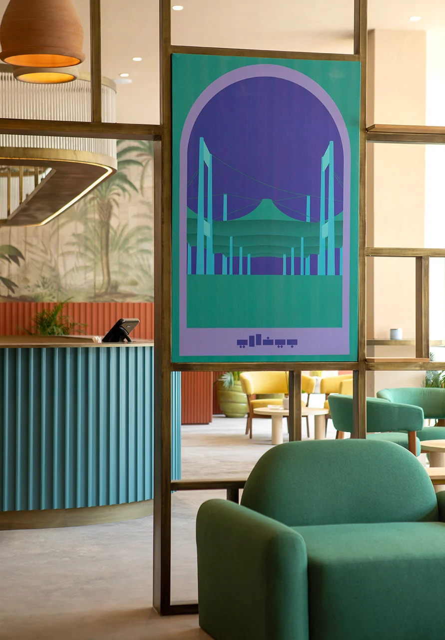 Caffè con poltrone verdi, un bancone scanalato verde petrolio e un poster incorniciato delle coperture del terminal – Biennale delle Arti Islamiche, Jeddah, Arabia Saudita, 2023 – architettura
