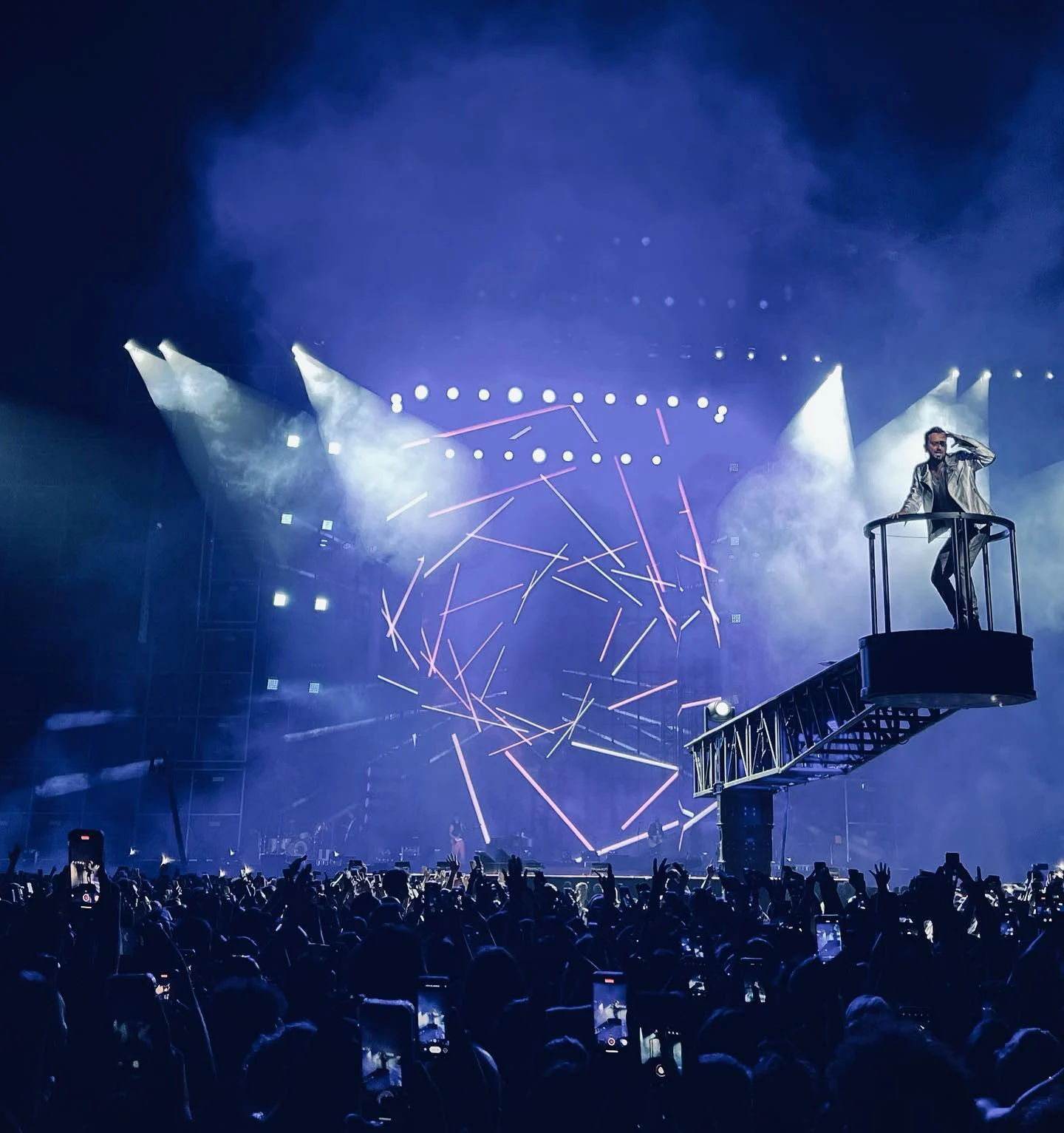Cesare Cremonini su una pedana rialzata in fondo a una passerella, linee laser sulla parete LED alle spalle – Cesare Cremonini Stadi 2022, Italia – scenografia per concerti