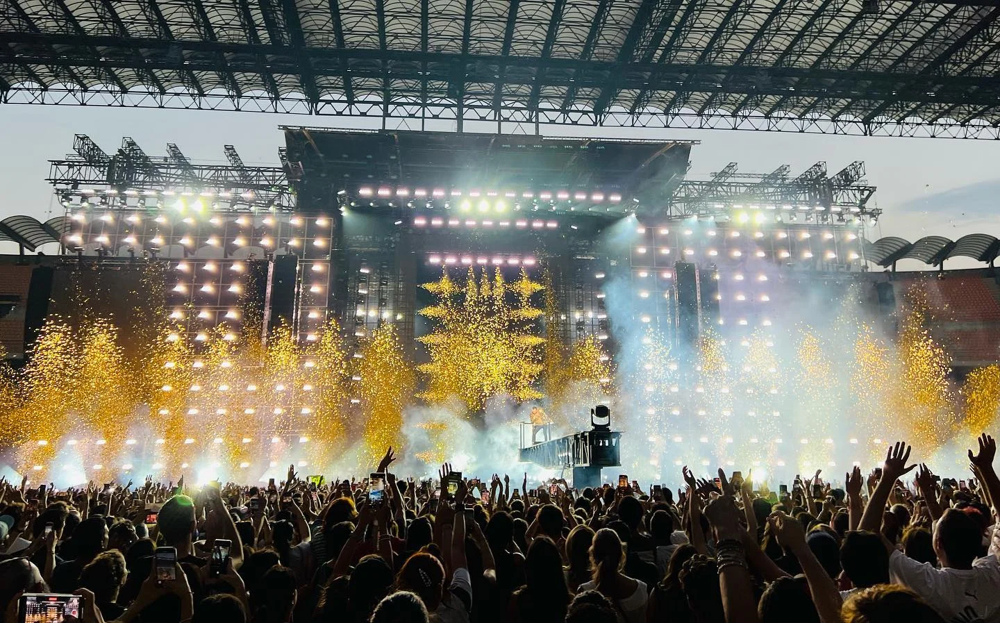 Concerto diurno allo stadio con fontane pirotecniche dorate lungo il palco e il pubblico in festa – Cesare Cremonini Stadi 2022, Italia – scenografia per concerti