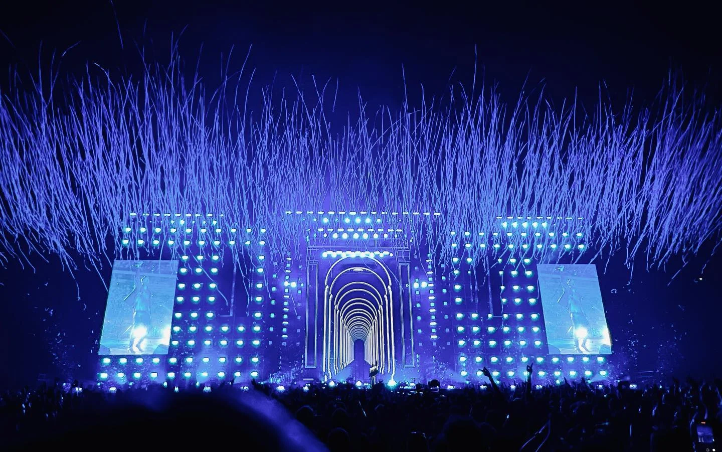 Palco da stadio immerso nel blu, stelle filanti che esplodono sopra il portale e la sua fuga di archi – Cesare Cremonini Stadi 2022, Italia – scenografia per concerti