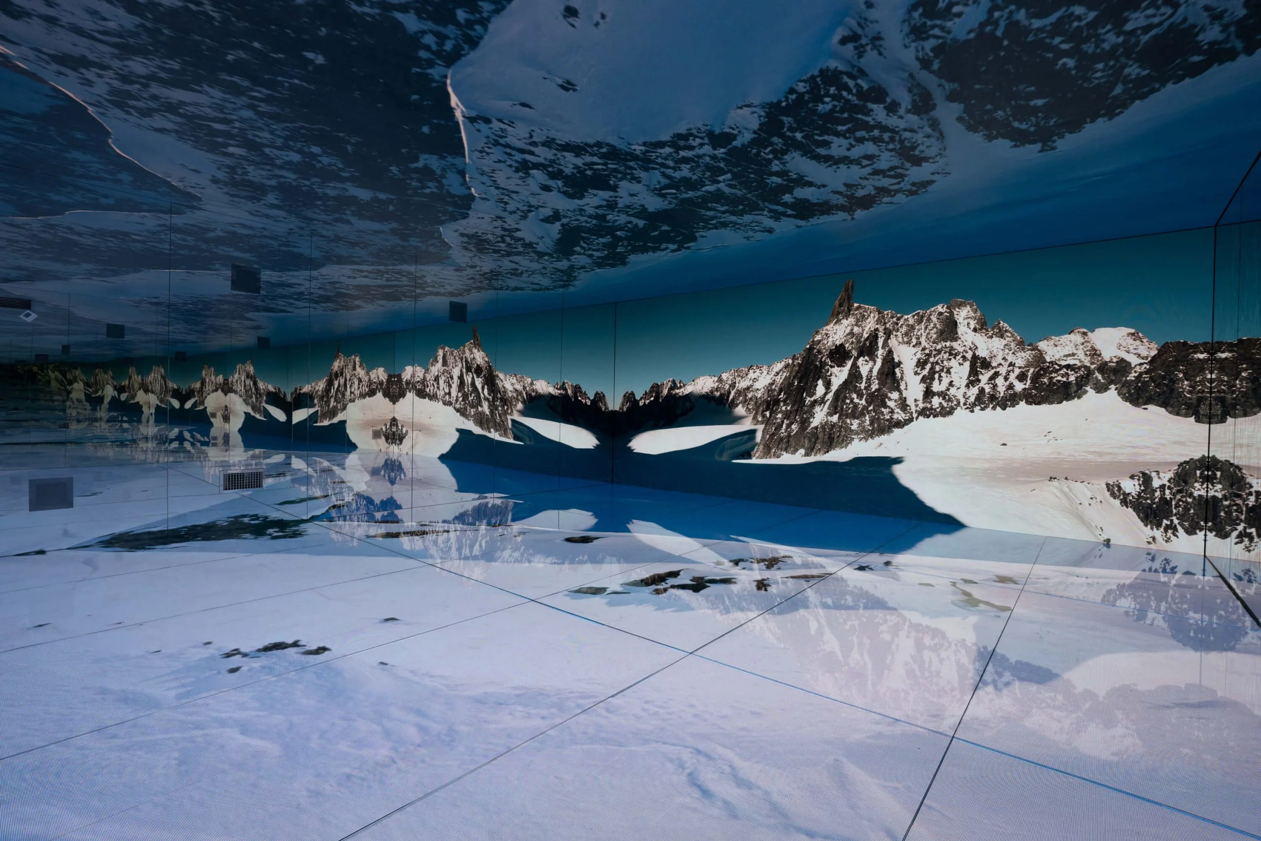 Ghiacciaio innevato sul pavimento e sulle pareti LED, con vette frastagliate ripetute all'infinito negli specchi – Mont Blanc Infinity Room allo Skyway, Courmayeur, Italia, 2023 – progettazione di installazioni