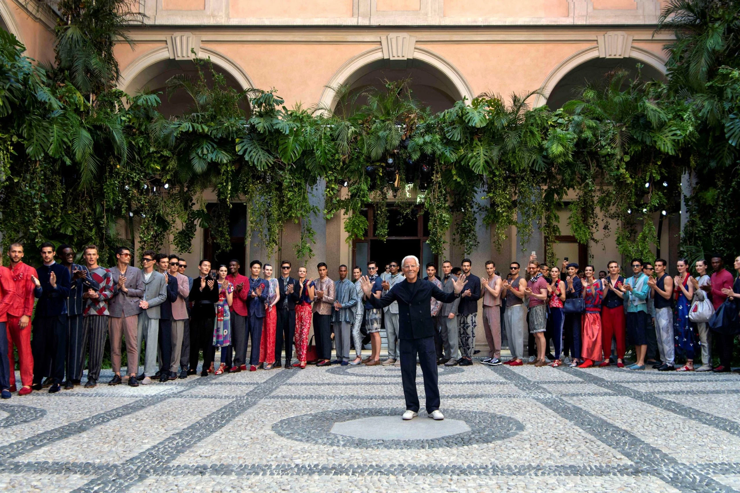 Lo stilista e i modelli in fila per il finale nel chiostro, sotto archi coperti di piante – Giorgio Armani SS20 Uomo e Donna, Milano, Italia, 2019 – scenografia per sfilate