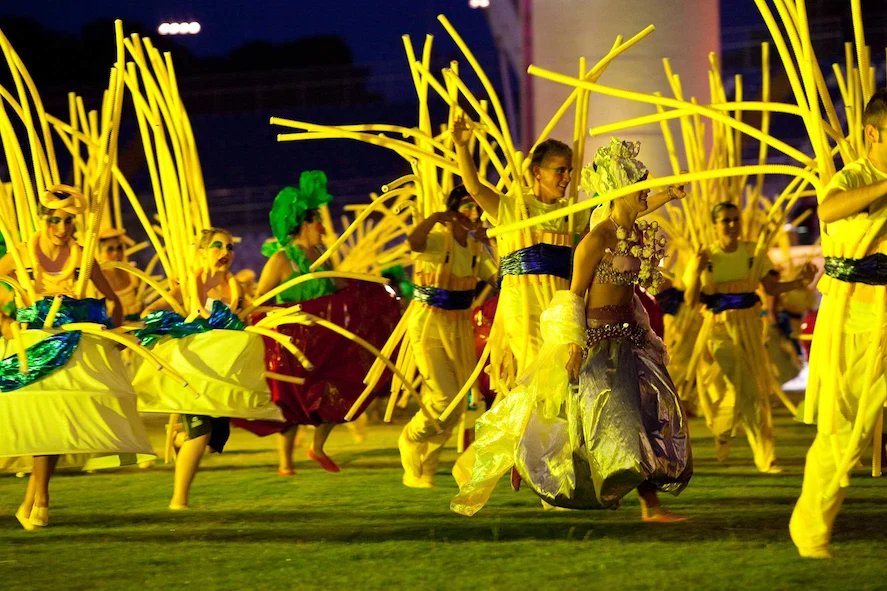 Artisti in costumi gialli con alte aste flessibili gialle che danzano sul prato – Cerimonia di apertura dei Giochi del Mediterraneo Pescara 2009, Italia, 2019 – progettazione di eventi