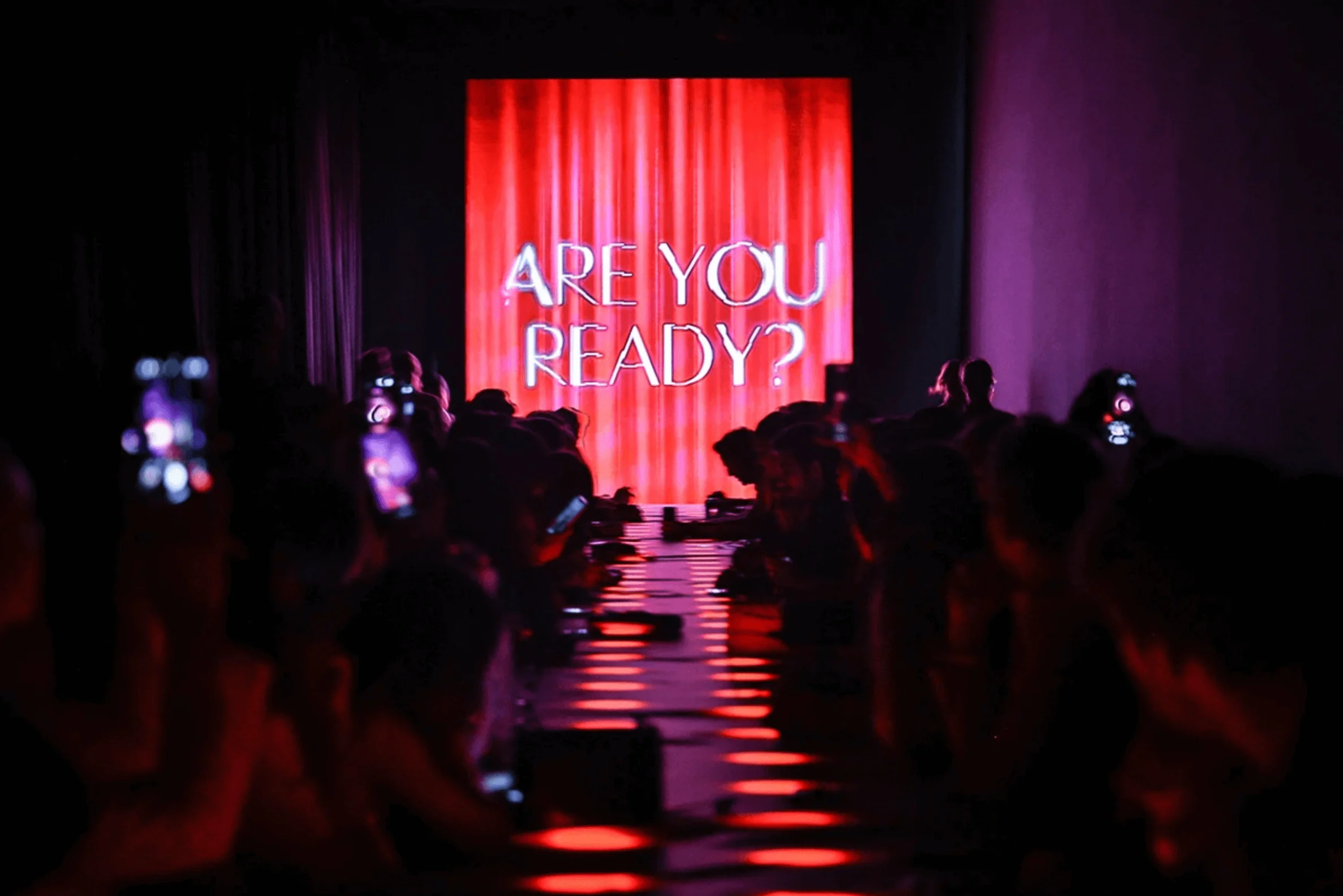 Schermo LED rosso con la scritta Are You Ready? in fondo a una passerella illuminata con ospiti ai lati – Campari Discover Red Party al Festival di Cannes, Francia, 2023 – progettazione di eventi
