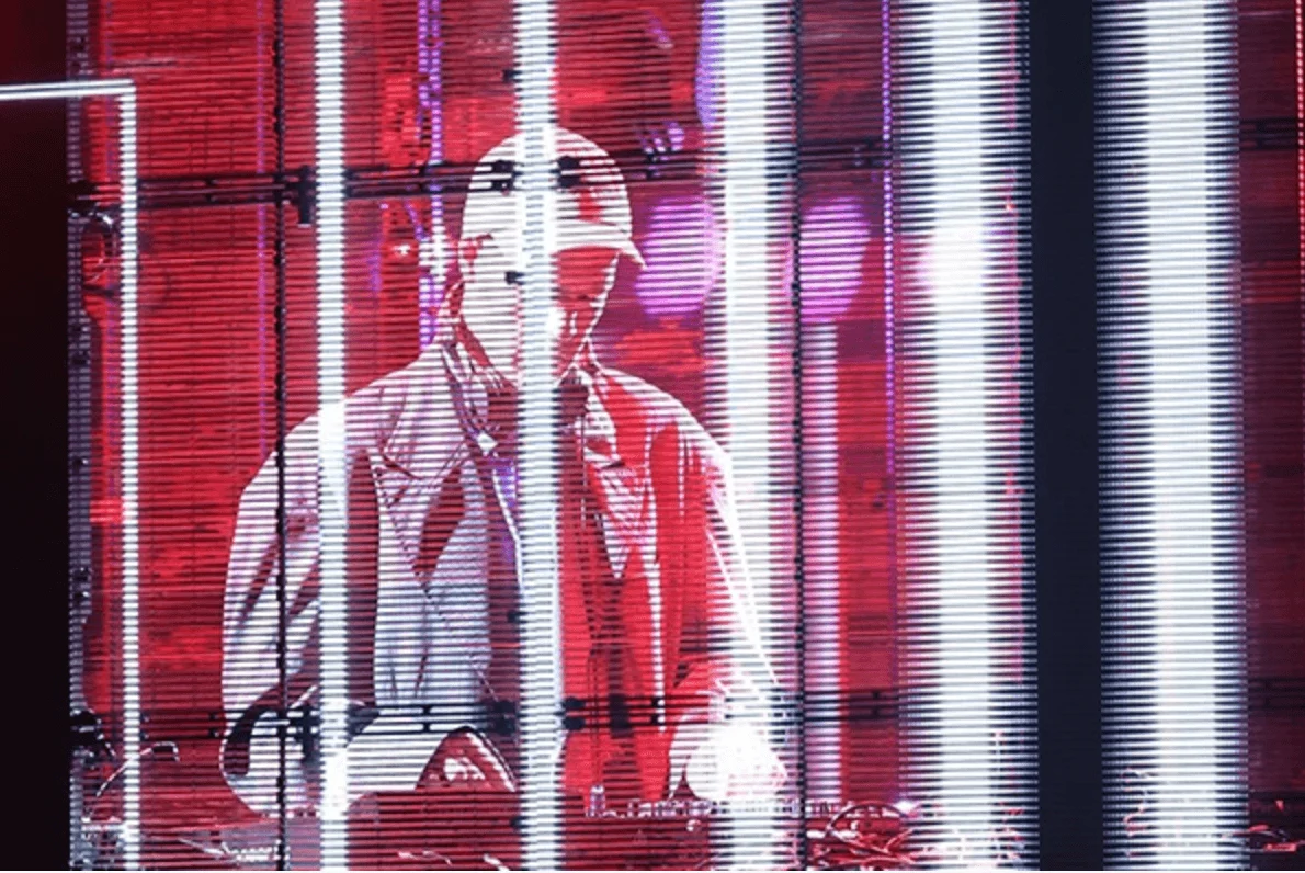 DJ visto attraverso uno schermo LED rosso trasparente con strisce verticali di luce bianca – Campari Discover Red Party al Festival di Cannes, Francia, 2023 – progettazione di eventi