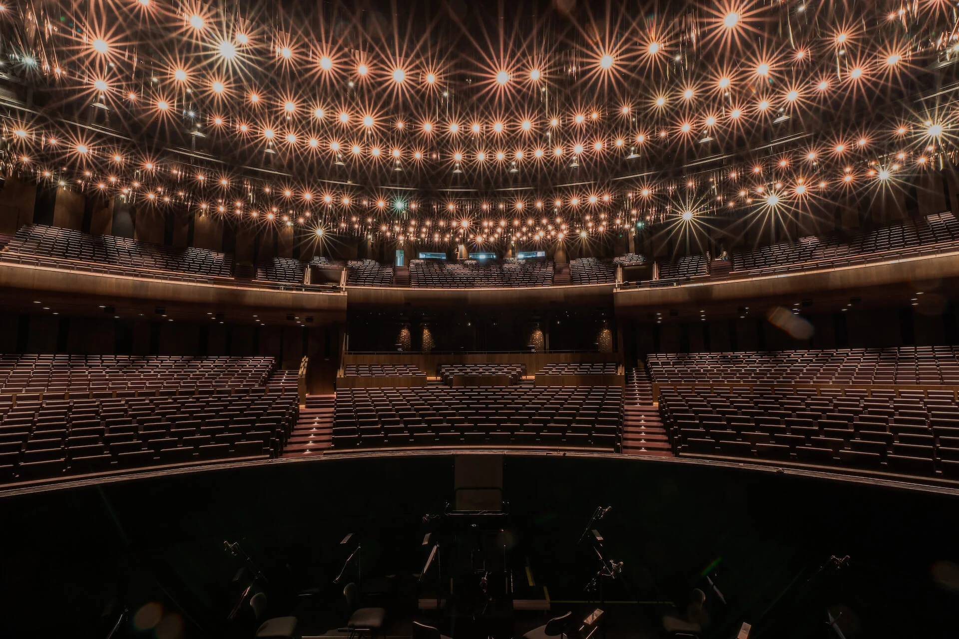 Sala vista dal palcoscenico, platea e balconate vuote sotto un soffitto di luci a raggiera – King Fahad Cultural Center, Riyadh, Arabia Saudita, 2024 – riqualificazione architettonica