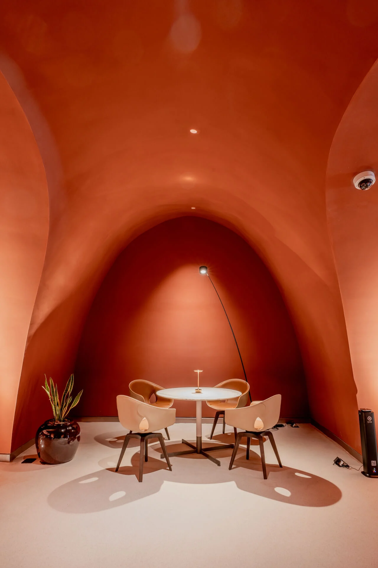 Tavolino rotondo con quattro sedie e una lampada ad arco in un'alcova voltata in terracotta – King Fahad Cultural Center, Riyadh, Arabia Saudita, 2024 – riqualificazione architettonica
