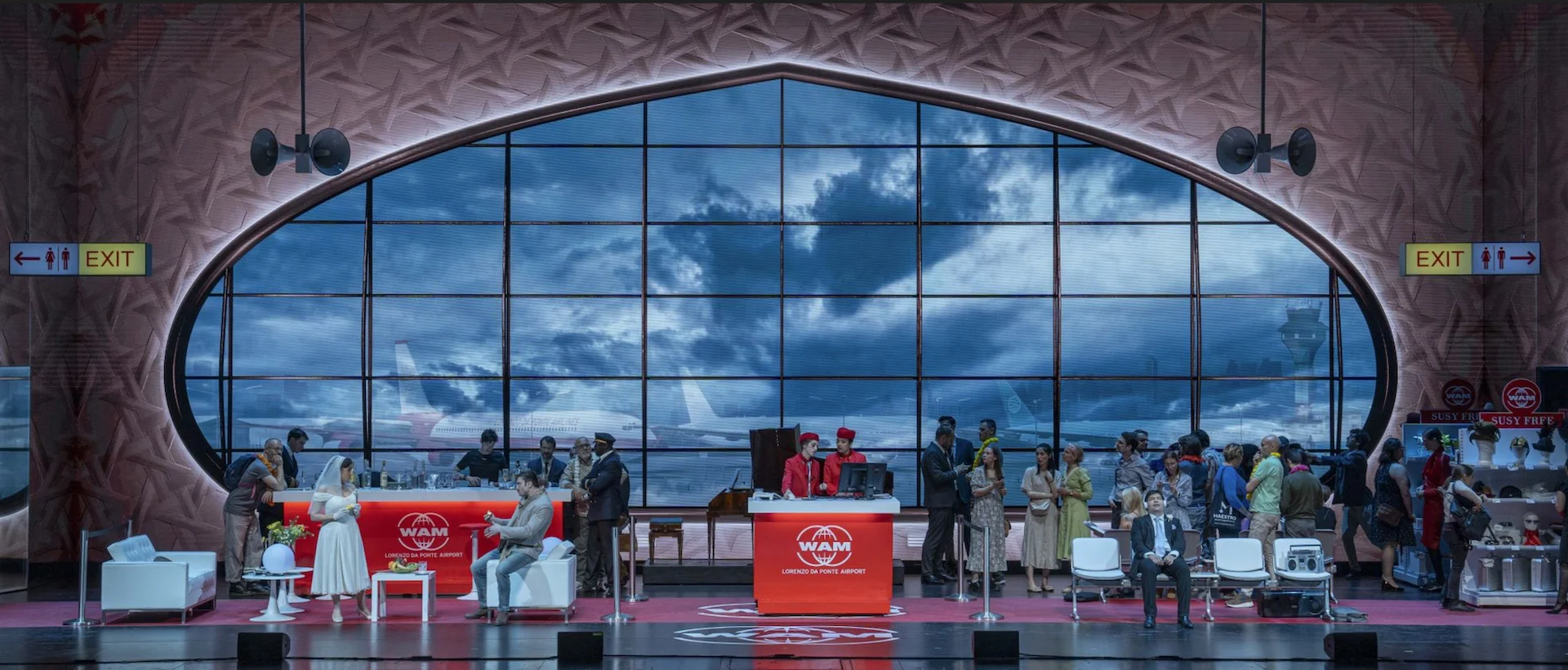 Scenografia di Une Folle Journée: un terminal aeroportuale con un'enorme finestra ovale, banchi del check-in e tutto il cast – Une Folle Journée Mozart Gala, Salisburgo, Austria, 2024 – scenografia d'opera