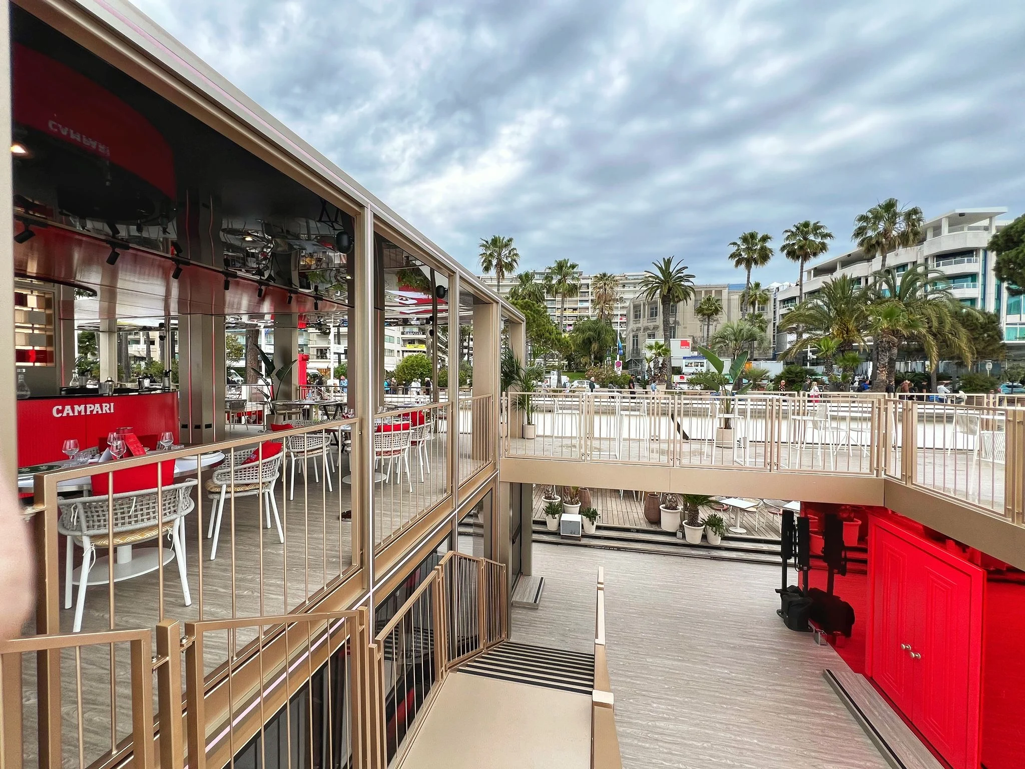Terrazza superiore del padiglione Campari affacciata sulle palme e sugli edifici della Croisette – Campari al Festival di Cannes 2024, Francia – architettura per eventi