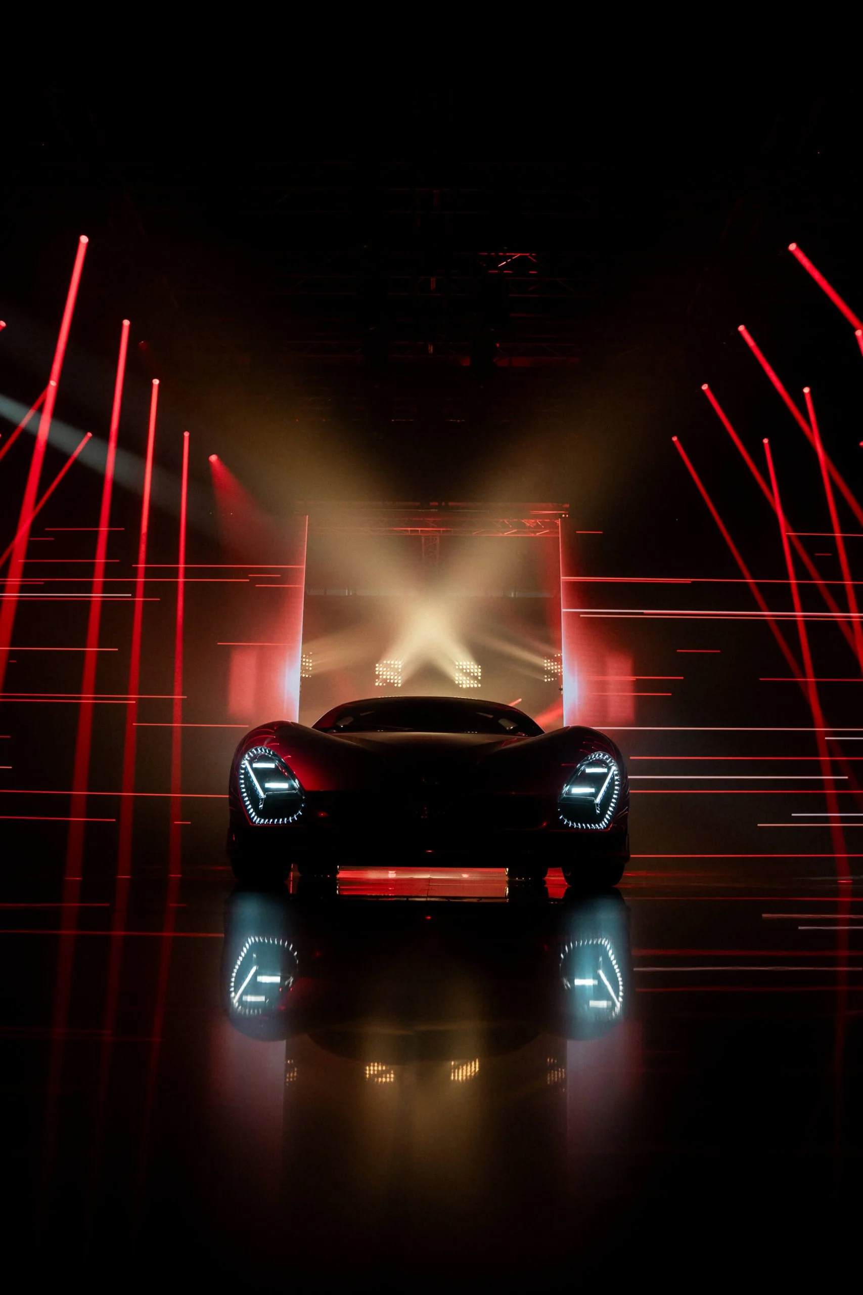 Frontale della nuova 33 Stradale con i fari accesi, incorniciato da linee laser rosse e una croce di luce bianca – Presentazione Alfa Romeo 33 Stradale, Arese, Italia, 2023 – progettazione di eventi
