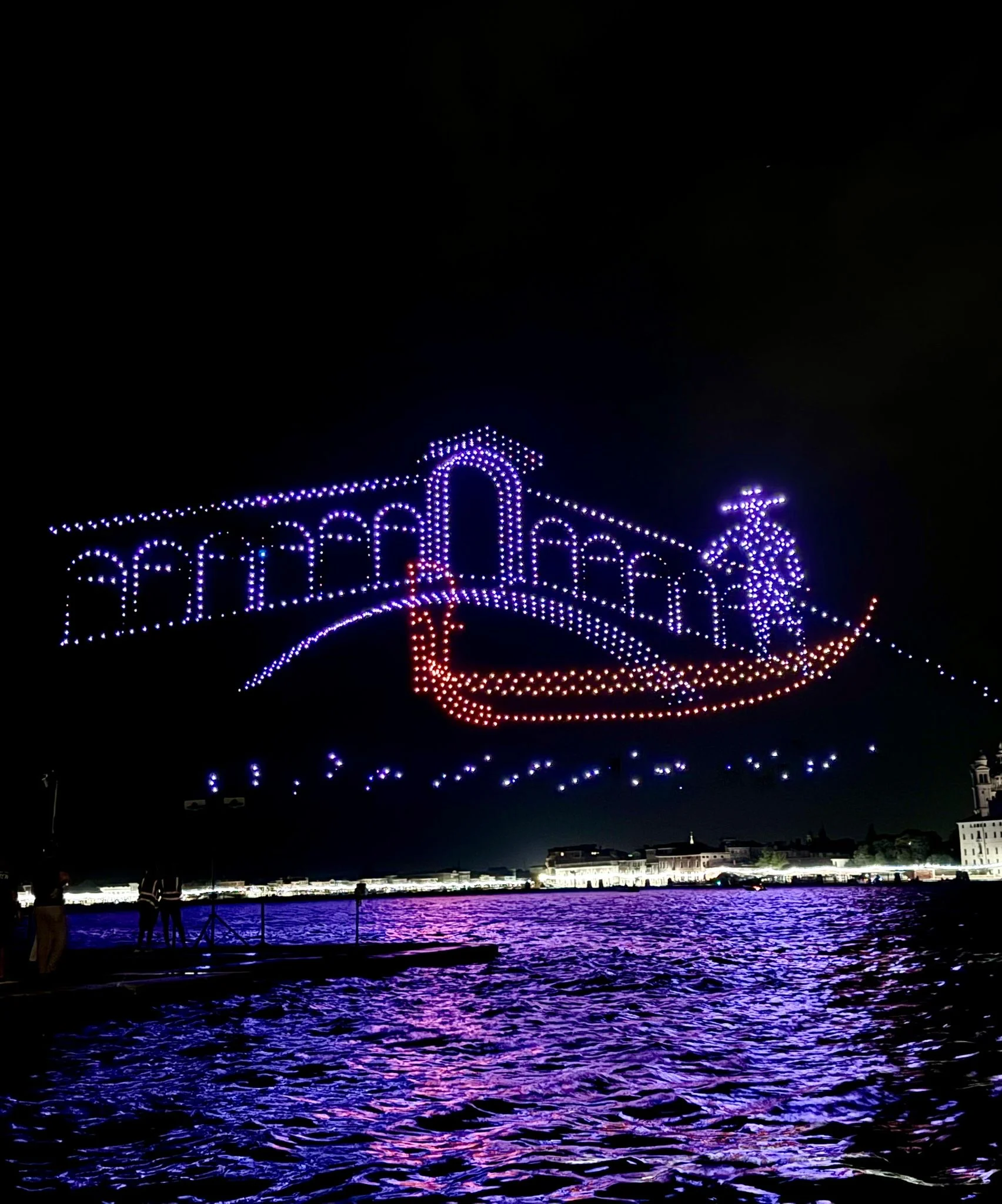 Droni che formano un ponte ad arco e una gondola con gondoliere sopra l'acqua di notte – Aperol Redentore Drone Show, Venezia, Italia, 2024 – direzione creativa