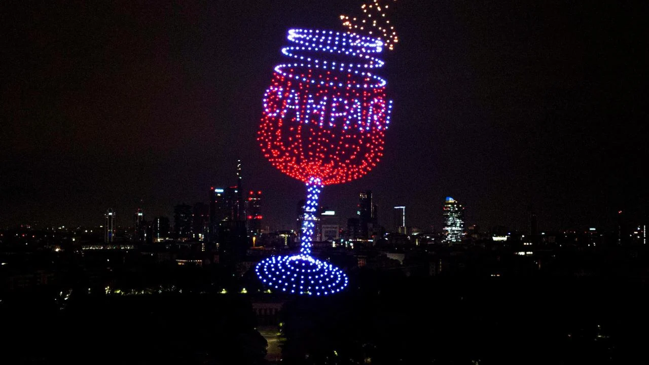 Droni che disegnano un bicchiere Campari con luci rosse e blu sopra lo skyline di Milano – Milano House of Campari, Italia, 2023 – progettazione di eventi