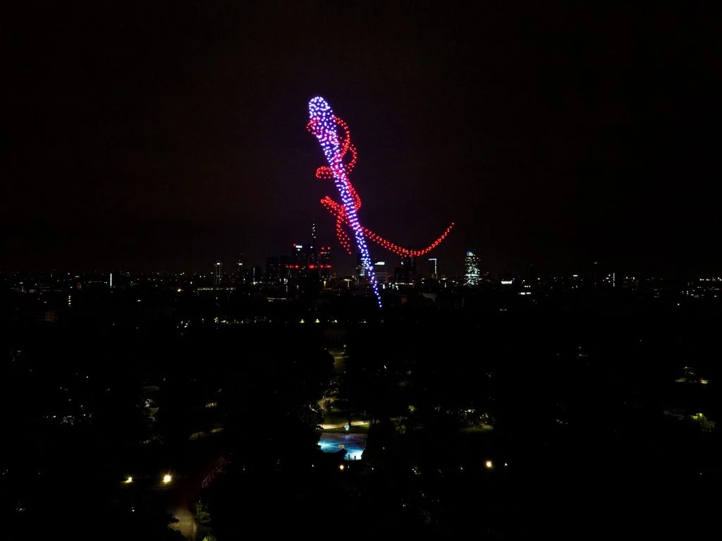 Formazione di droni a forma di ago e filo rosso sopra lo skyline di Milano di notte – Milano House of Campari, Italia, 2023 – progettazione di eventi