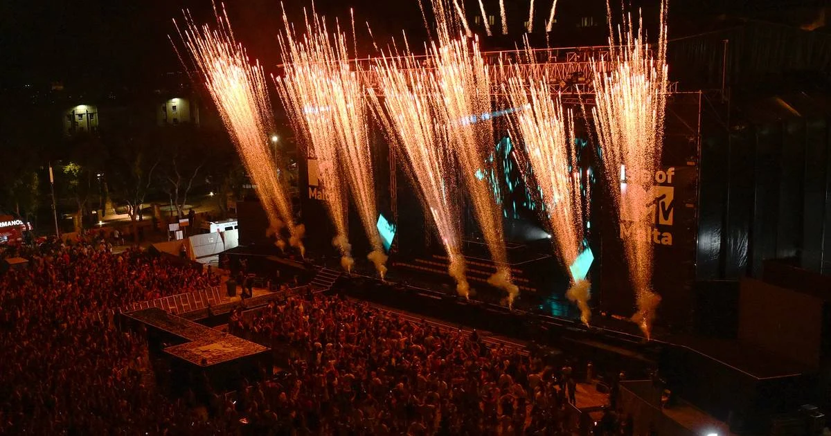 Vista dall'alto del palco di notte mentre una fila di fuochi d'artificio dorati esplode sopra la folla – Isle of MTV 2024, Floriana, Malta – scenografia per concerti