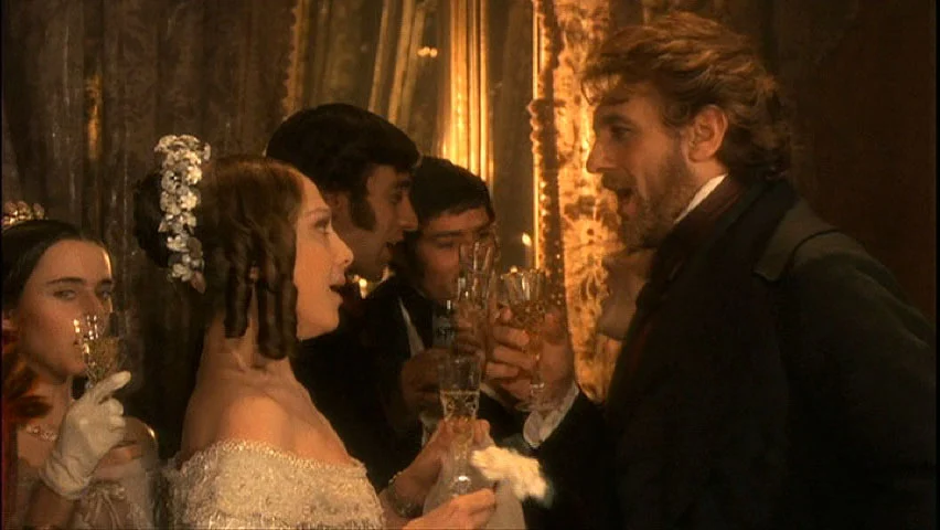 Fotogramma del film: ospiti in costume d'epoca che brindano con lo champagne in un salone dorato – The Opera! Arie per un'Eclissi alla Festa del Cinema di Roma, Italia, 2024 – scenografia