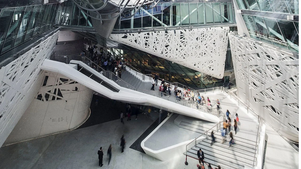 Interno di Palazzo Italia: ponti-scala bianchi scolpiti che attraversano l'atrio tra pareti traforate – Padiglione Italia all'Expo 2015, Milano, Italia – allestimento espositivo