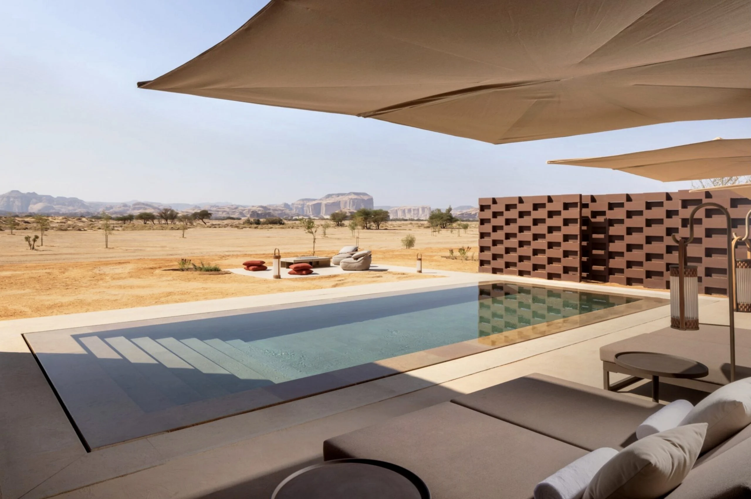 Piscina privata su una terrazza con lettini sotto tende in tessuto, affacciata sulla piana desertica – The Chedi Hegra, AlUla, Arabia Saudita, 2024 – architettura alberghiera