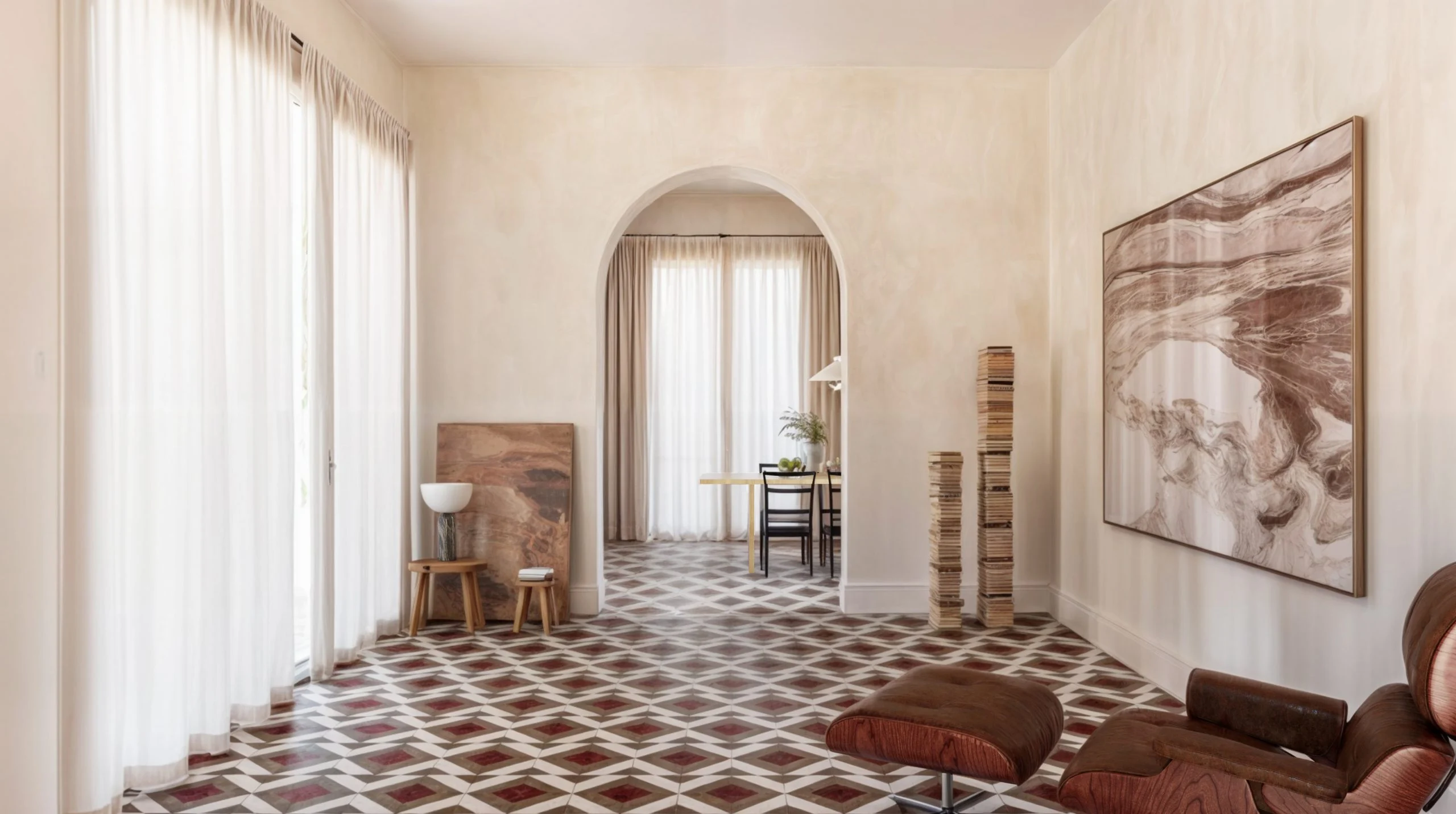 Soggiorno con pavimento in pietra intarsiata Murabba a motivo geometrico, porta ad arco e poltrona lounge in pelle – Pavimento Murabba per MIAMILANO, Italia, 2025 – design di prodotto
