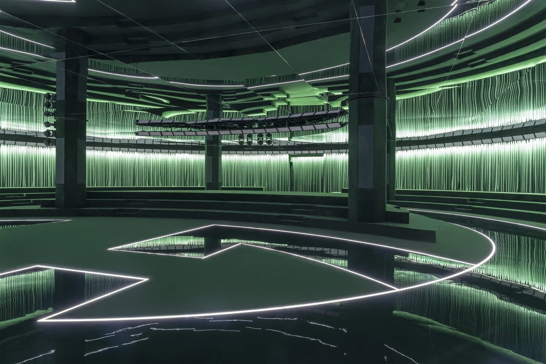 Vista d'insieme della location della sfilata vuota con la Interlocking G disegnata con la luce sul pavimento a specchio – Gucci Autunno/Inverno 2025, Milano, Italia – scenografia per sfilate