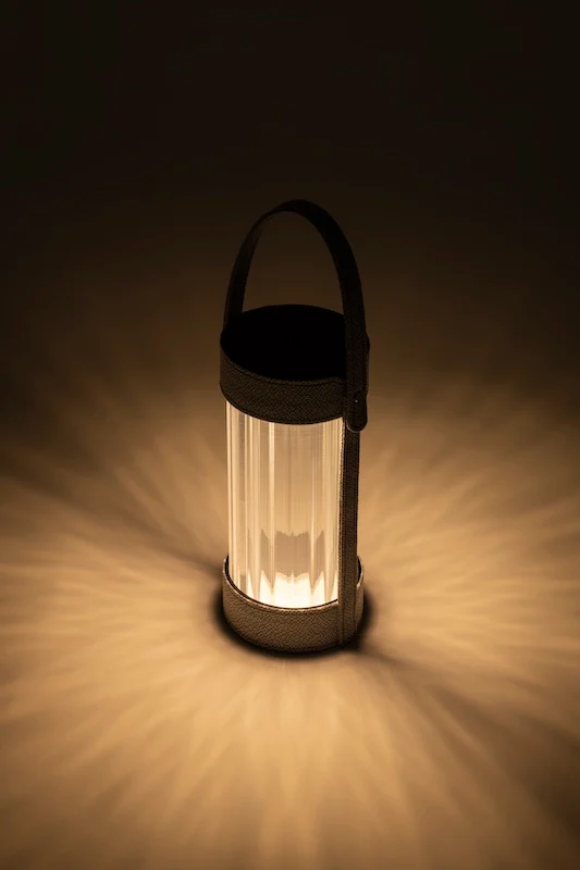 Lanterna accesa che proietta sul pavimento un motivo radiale di luce calda nel buio – Lanterna AlUla per Artemide, Milano, Italia, 2025 – lighting design