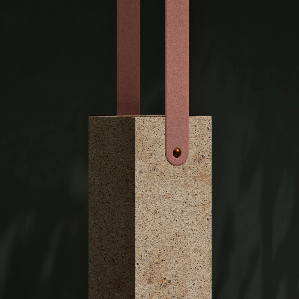 Dettaglio di una sospensione in pietra con cinghie di pelle rosa fissate da un rivetto metallico – Arredi in porfido Porfido Pedretti, Milano, Italia, 2025 – design di prodotto
