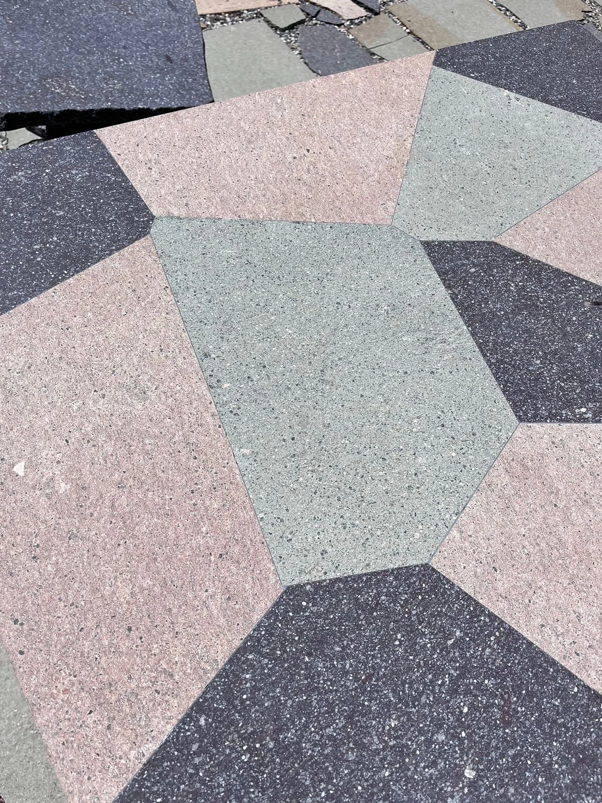 Dettaglio di un motivo geometrico di pezzi di porfido rosa, verde e grigio scuro – Collezione Frammenti per Porfido Pedretti, Milano, Italia, 2025 – design di prodotto
